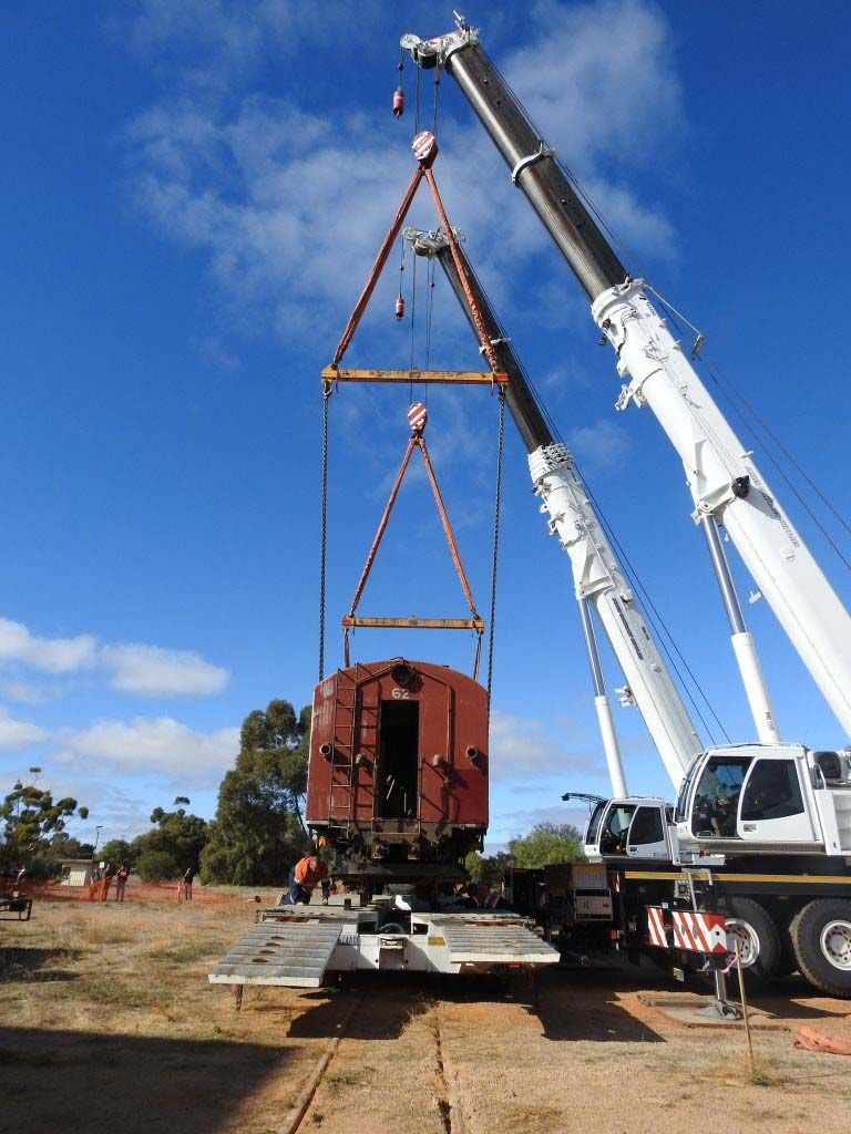 A crane is lifting a train car into the air
