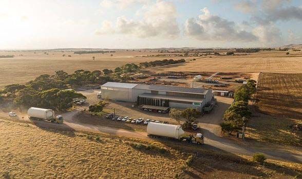 An aerial view of a large building in the middle of a field.