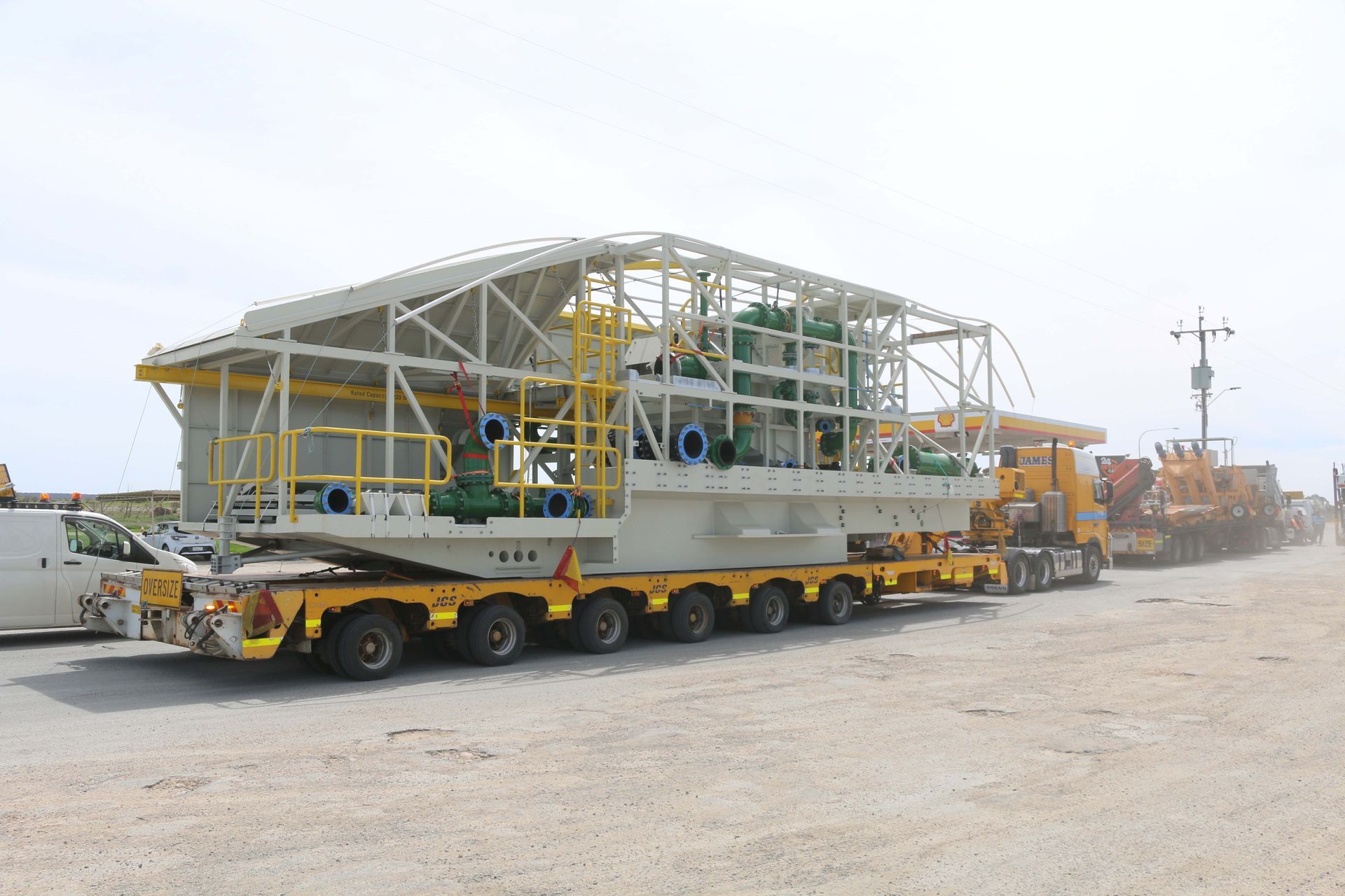A large truck is carrying a large structure on a trailer.