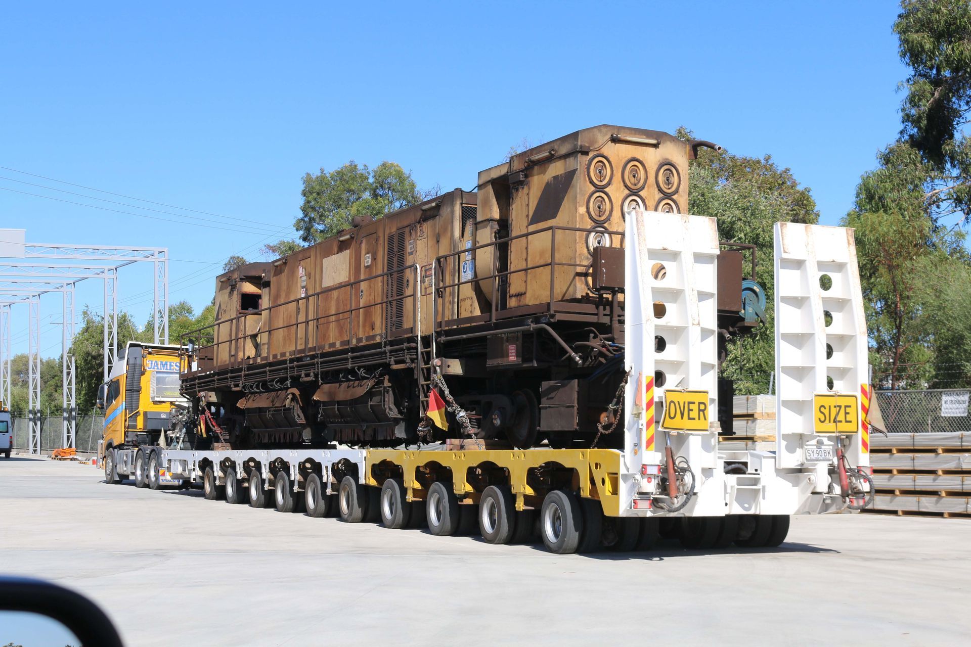 A train is being transported by a truck with a trailer attached to it.