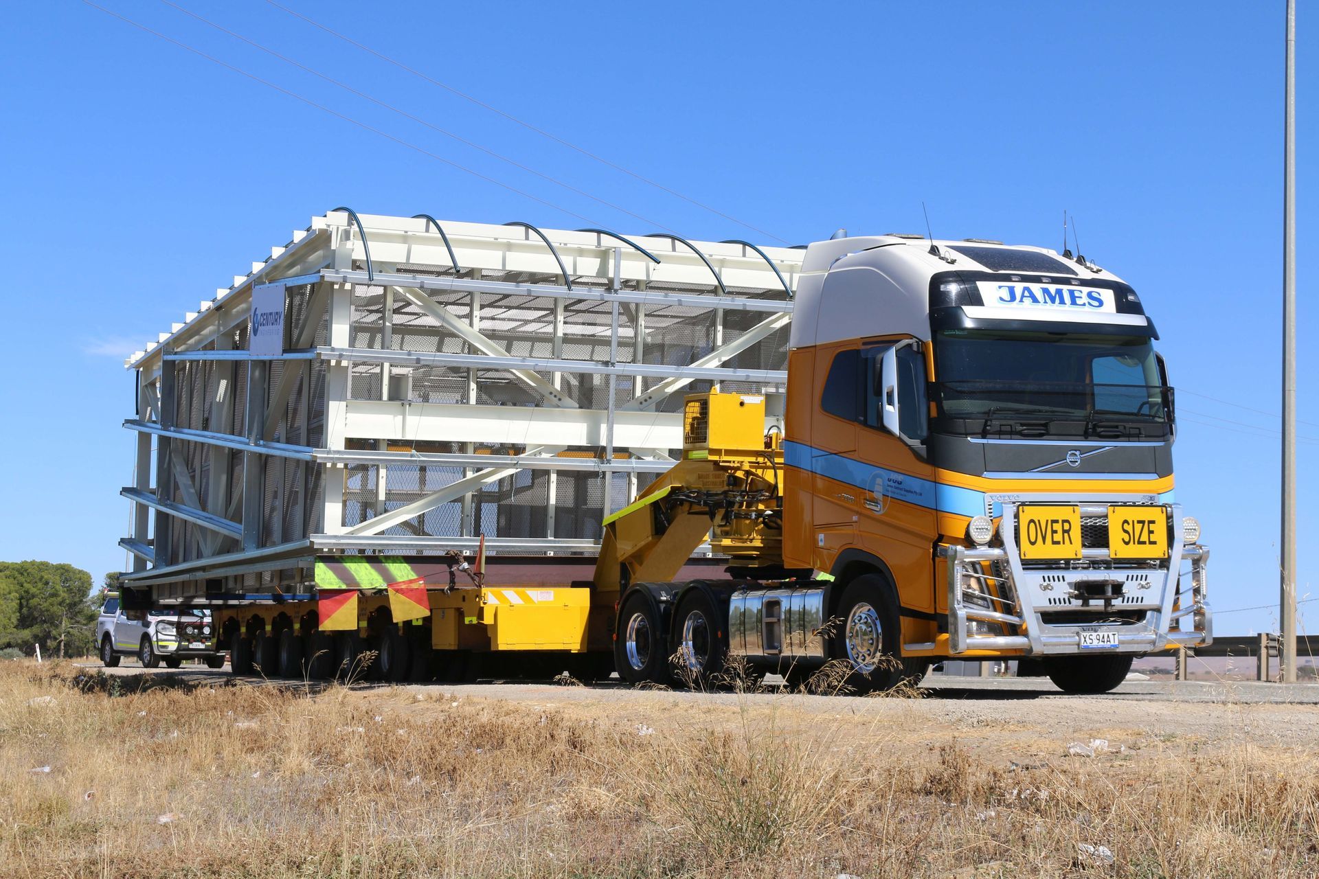A large truck is carrying a large structure on a trailer.