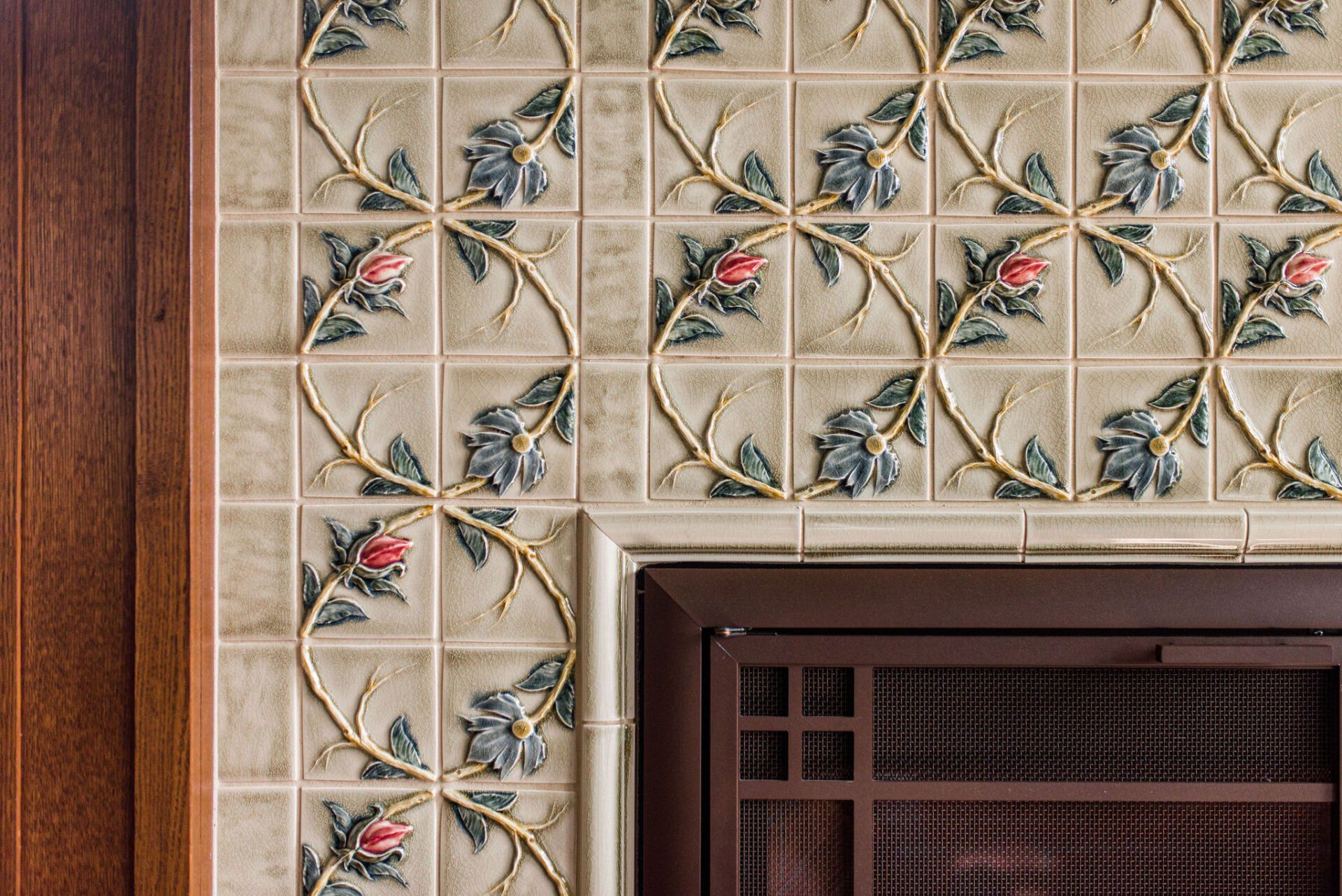 A fireplace with a floral tile design on it