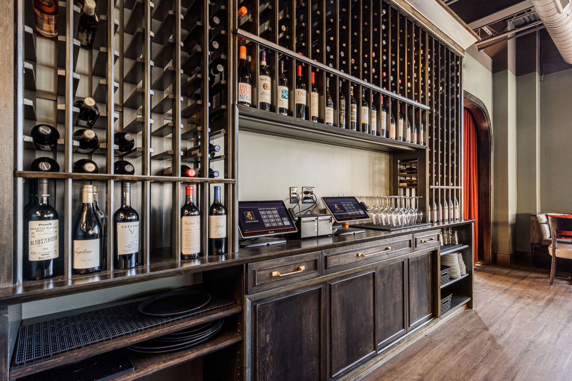 A bar with a lot of wine bottles on the shelves.