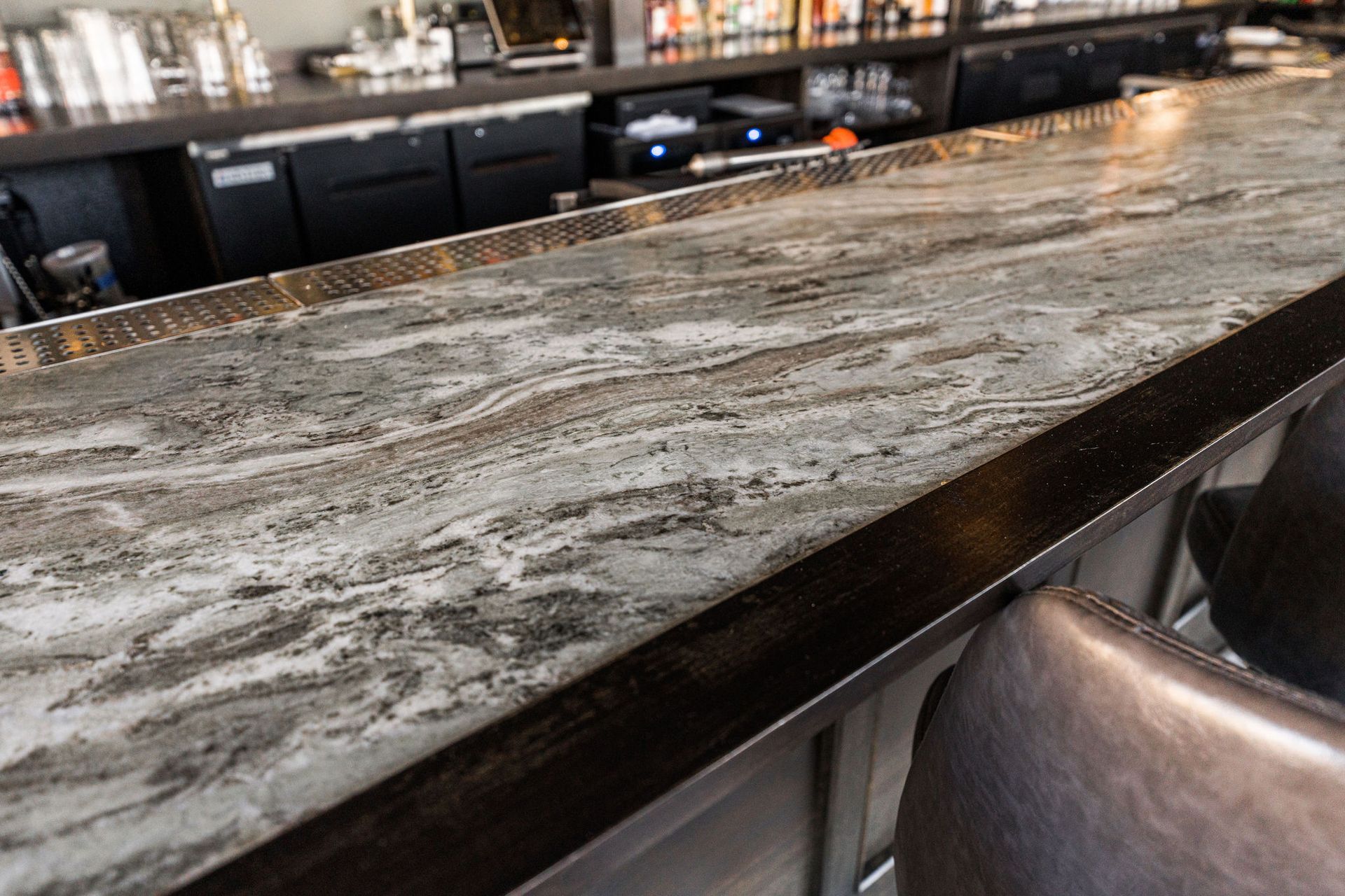 A bar with a marble counter top in a restaurant.
