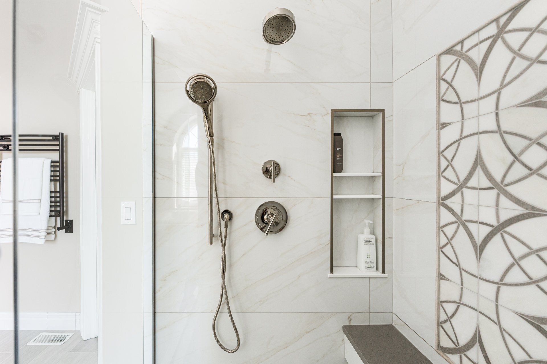A bathroom with a walk in shower and a bench.