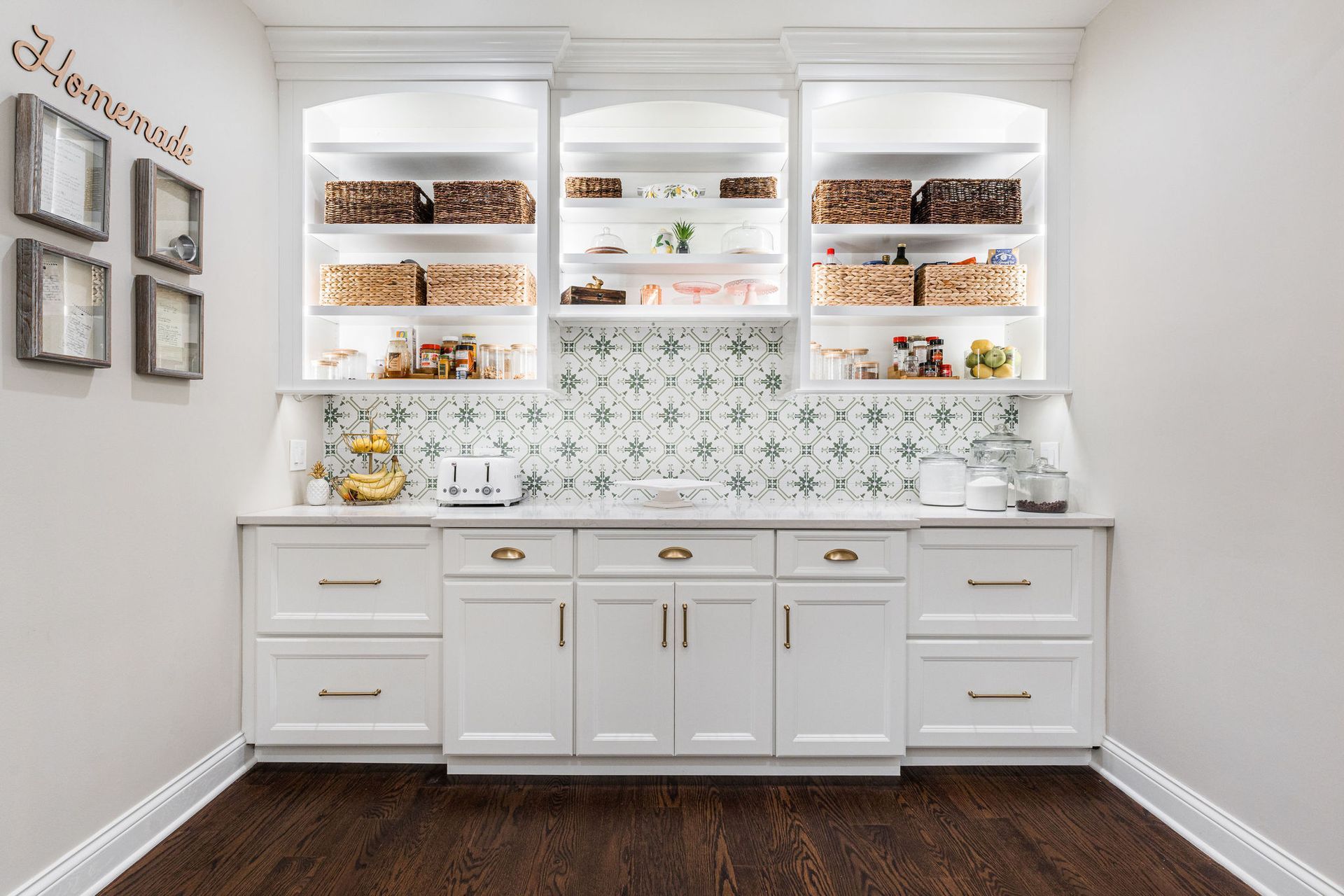 A kitchen with white cabinets , drawers , and shelves.