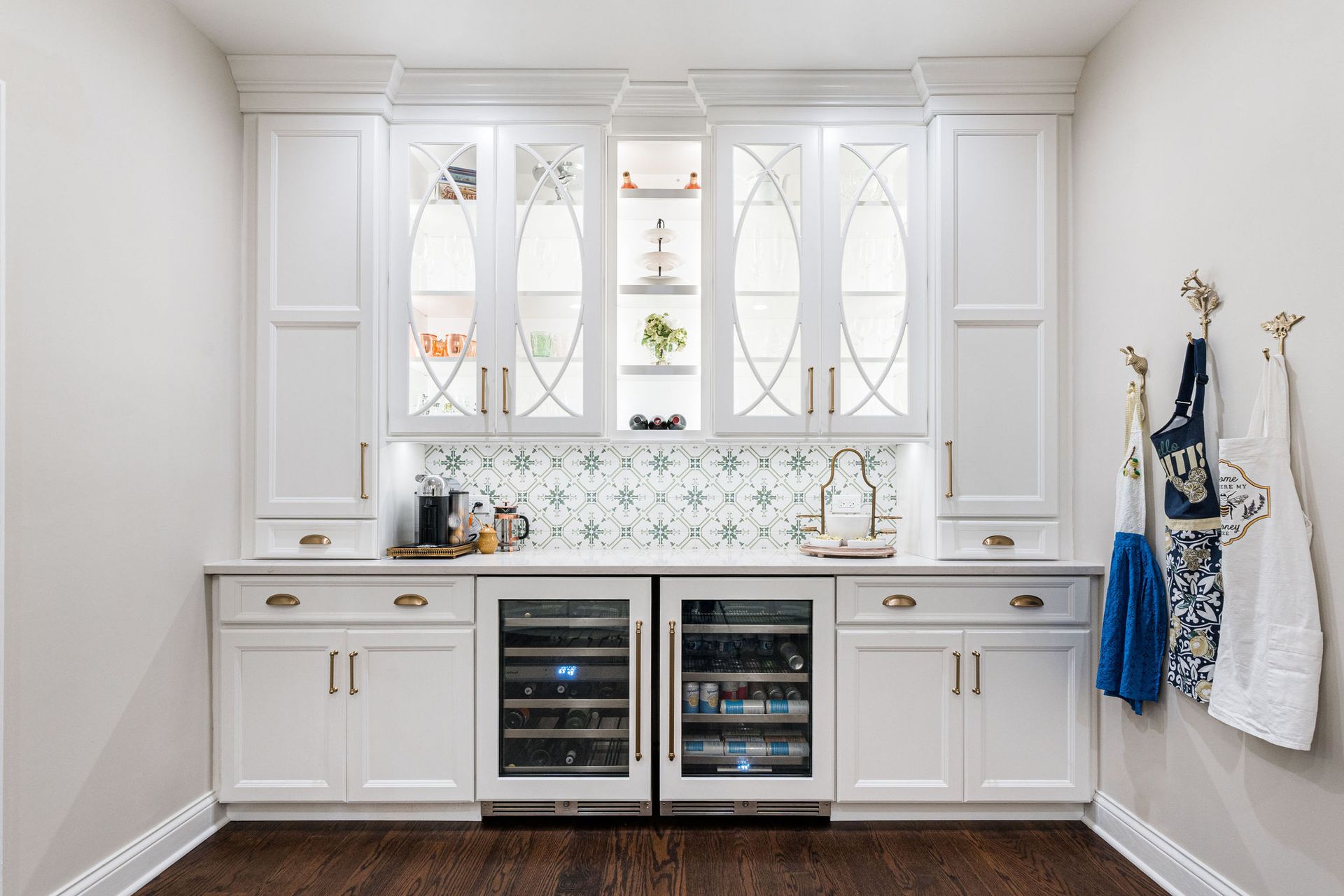 A kitchen with white cabinets , a refrigerator and a sink.