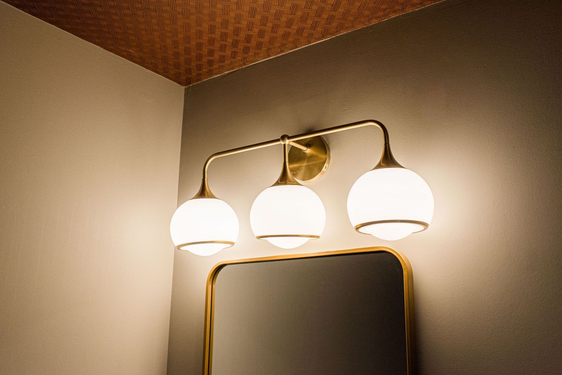A bathroom mirror with a light above it.
