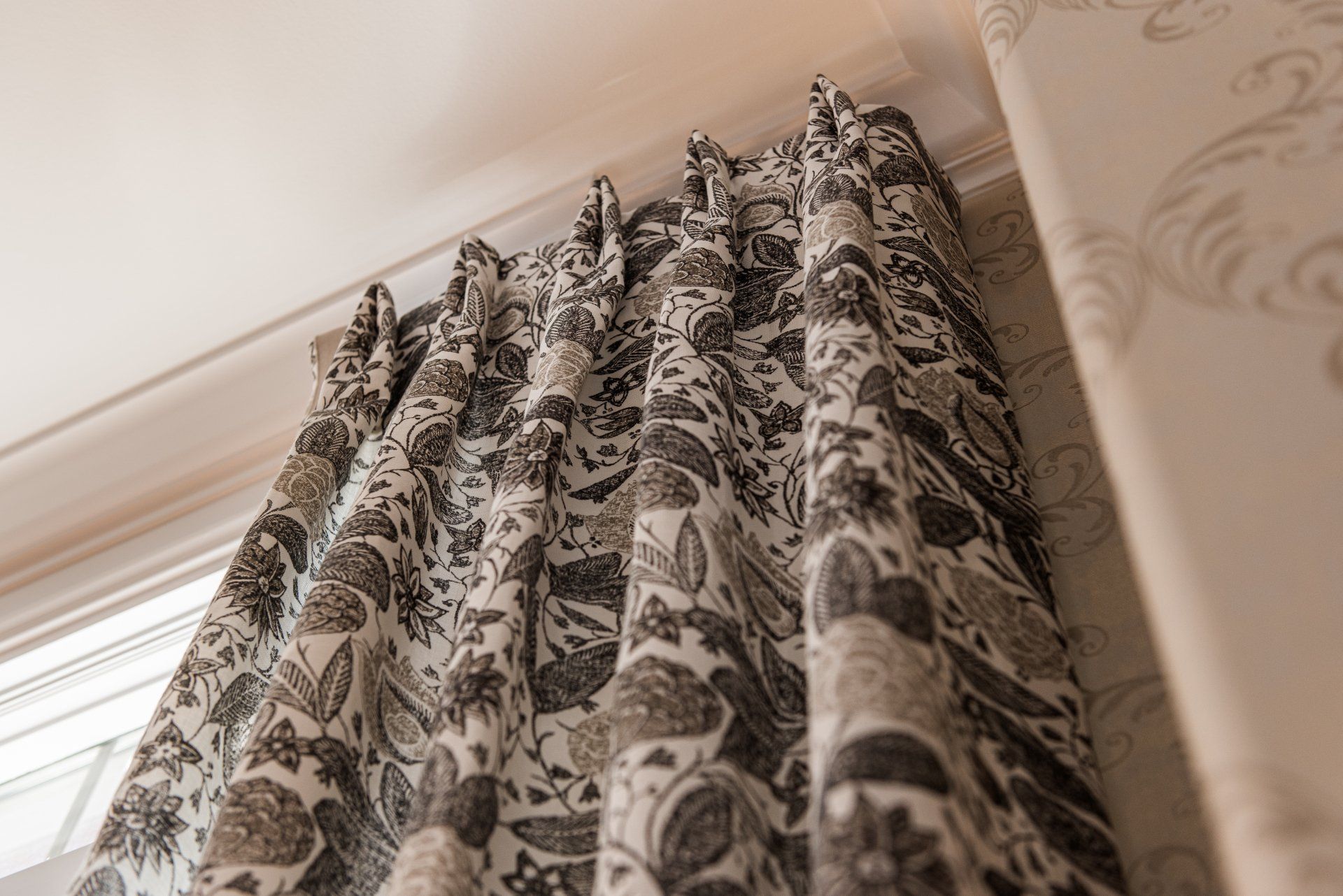 A close up of a pair of curtains hanging on a window.