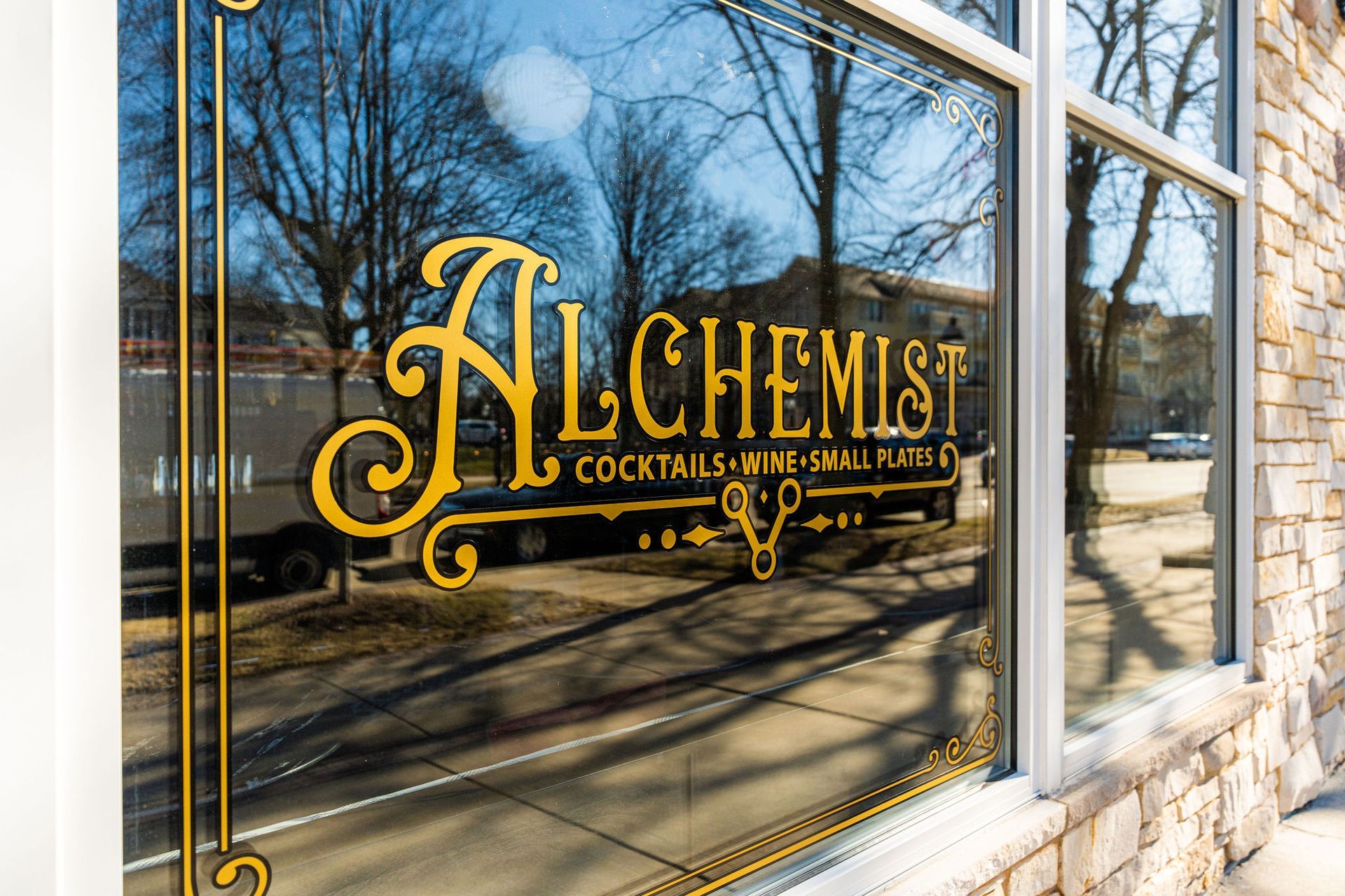 A window with a sign that says alchemist on it.