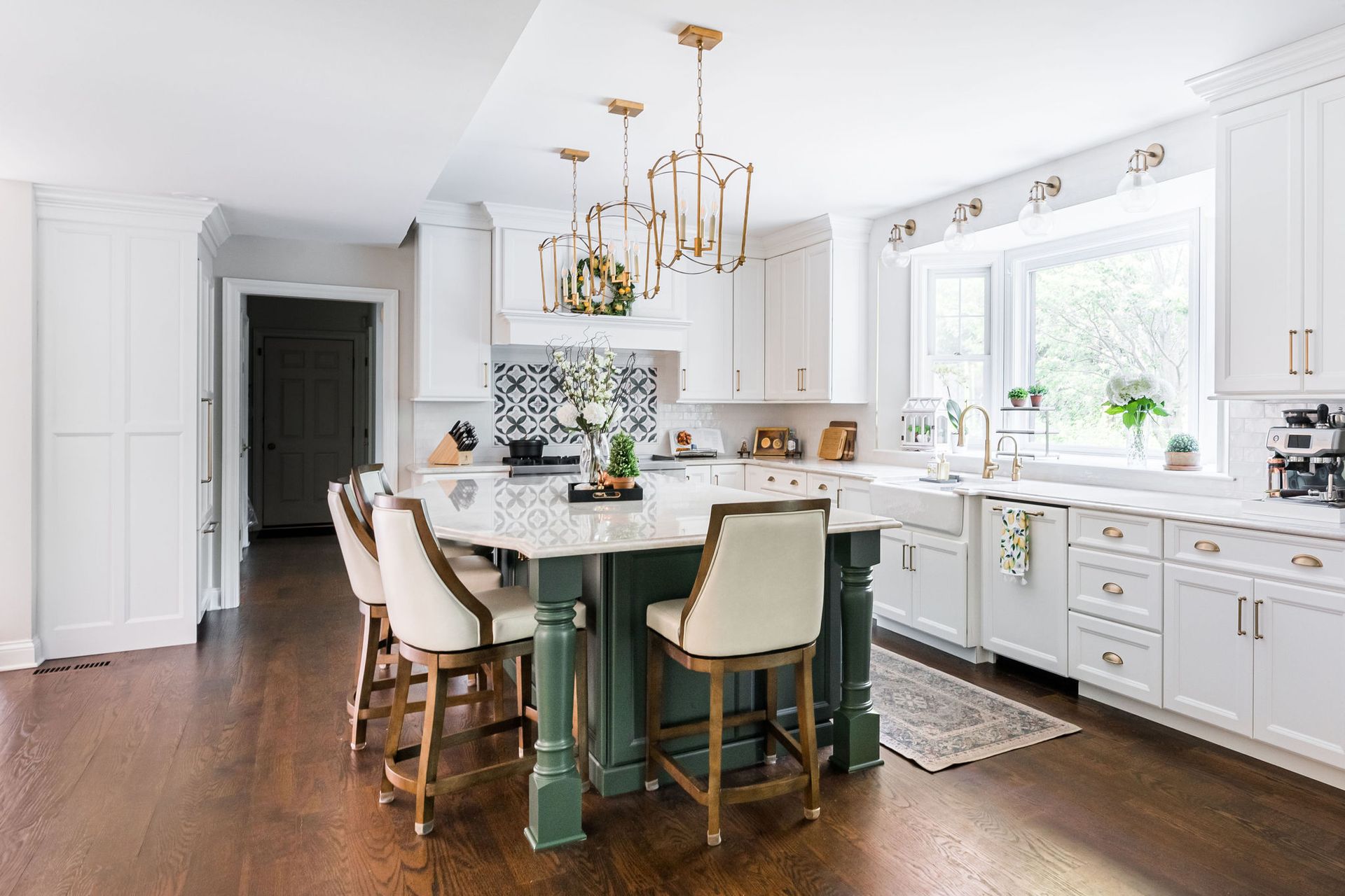 A kitchen with white cabinets and a green island.
