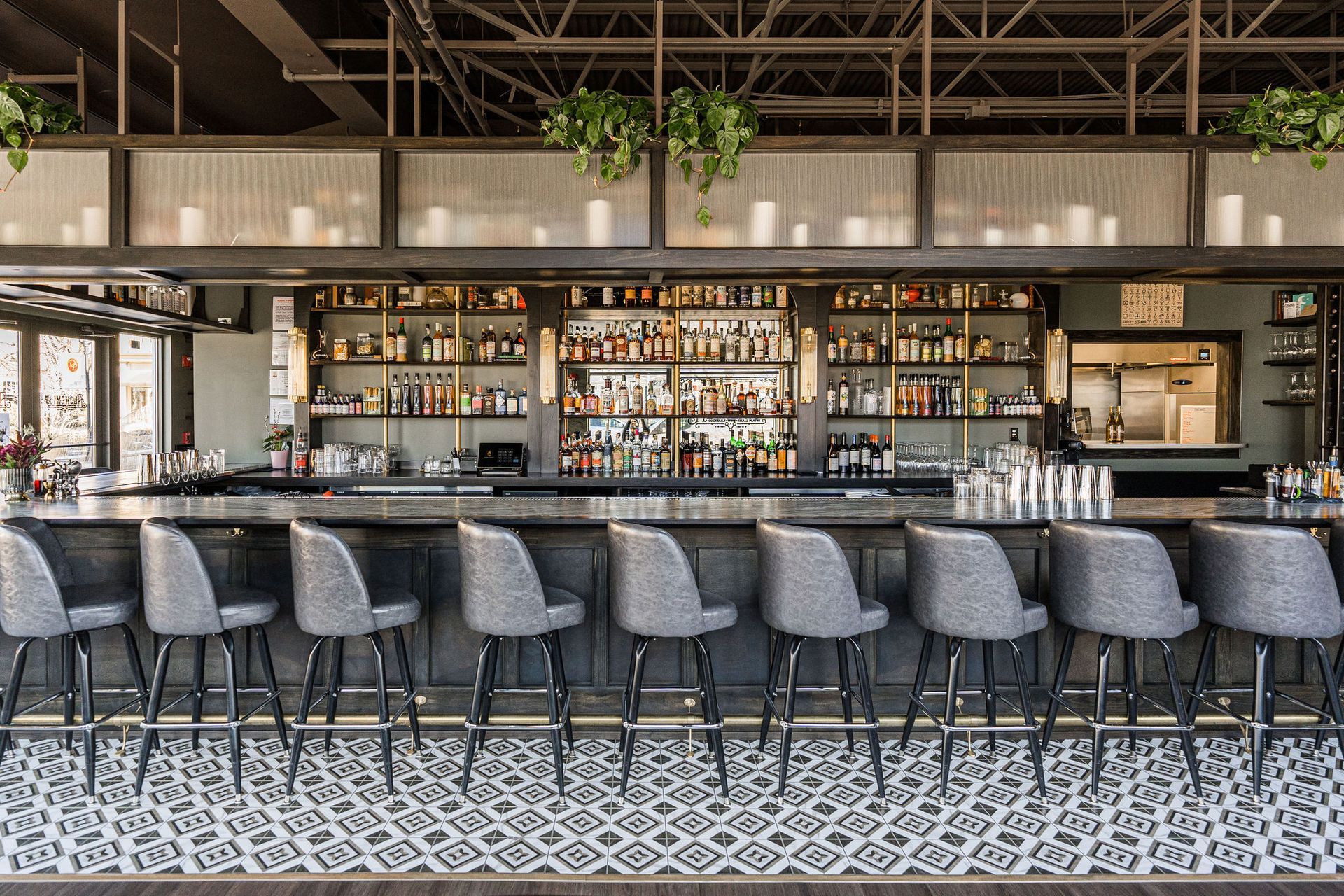 A long bar with a lot of shelves and chairs in a restaurant.