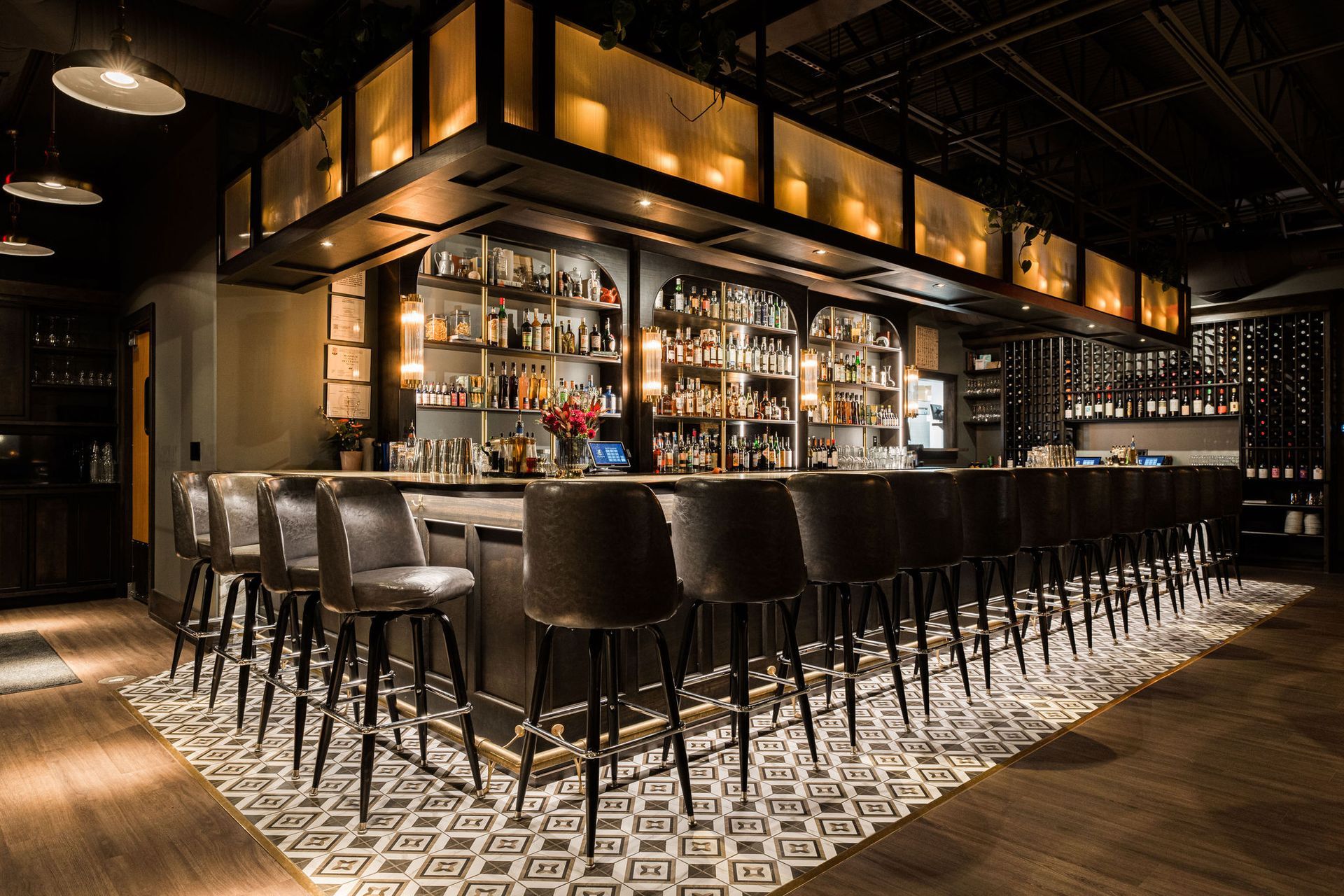 A restaurant with a long bar and lots of chairs.