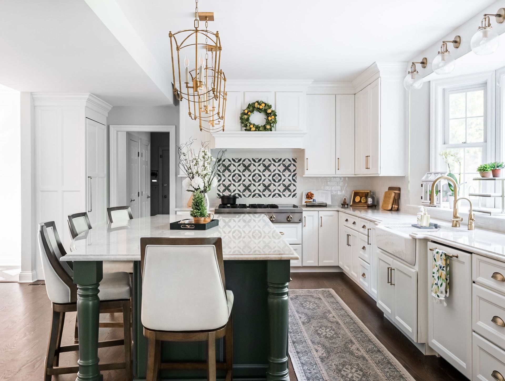 A kitchen with white cabinets and a green island.