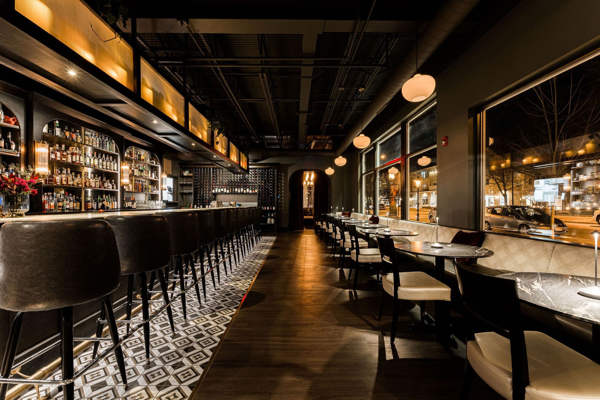A restaurant with tables and chairs and a bar.