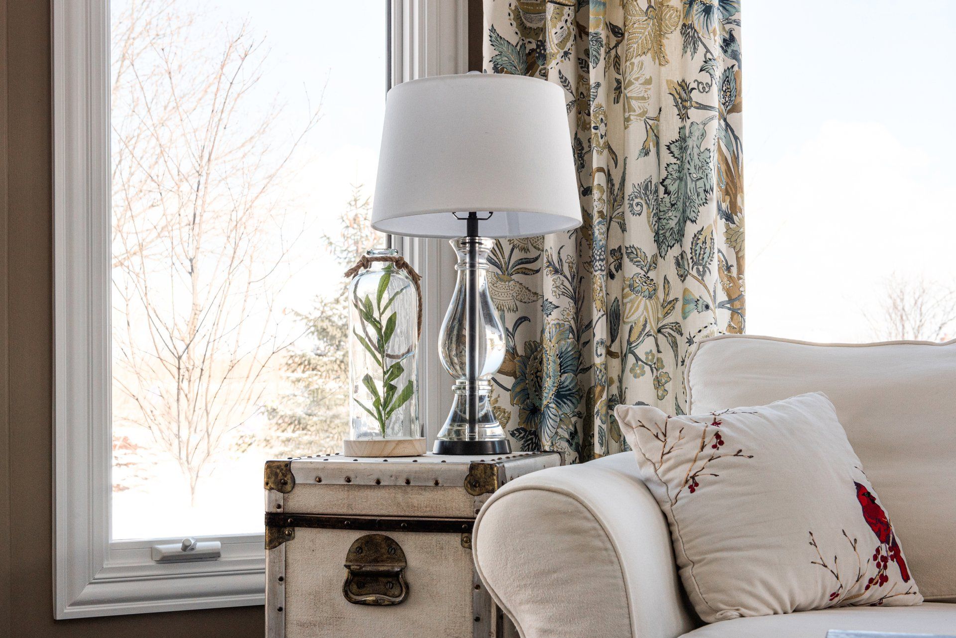 A living room with a couch a lamp and a window