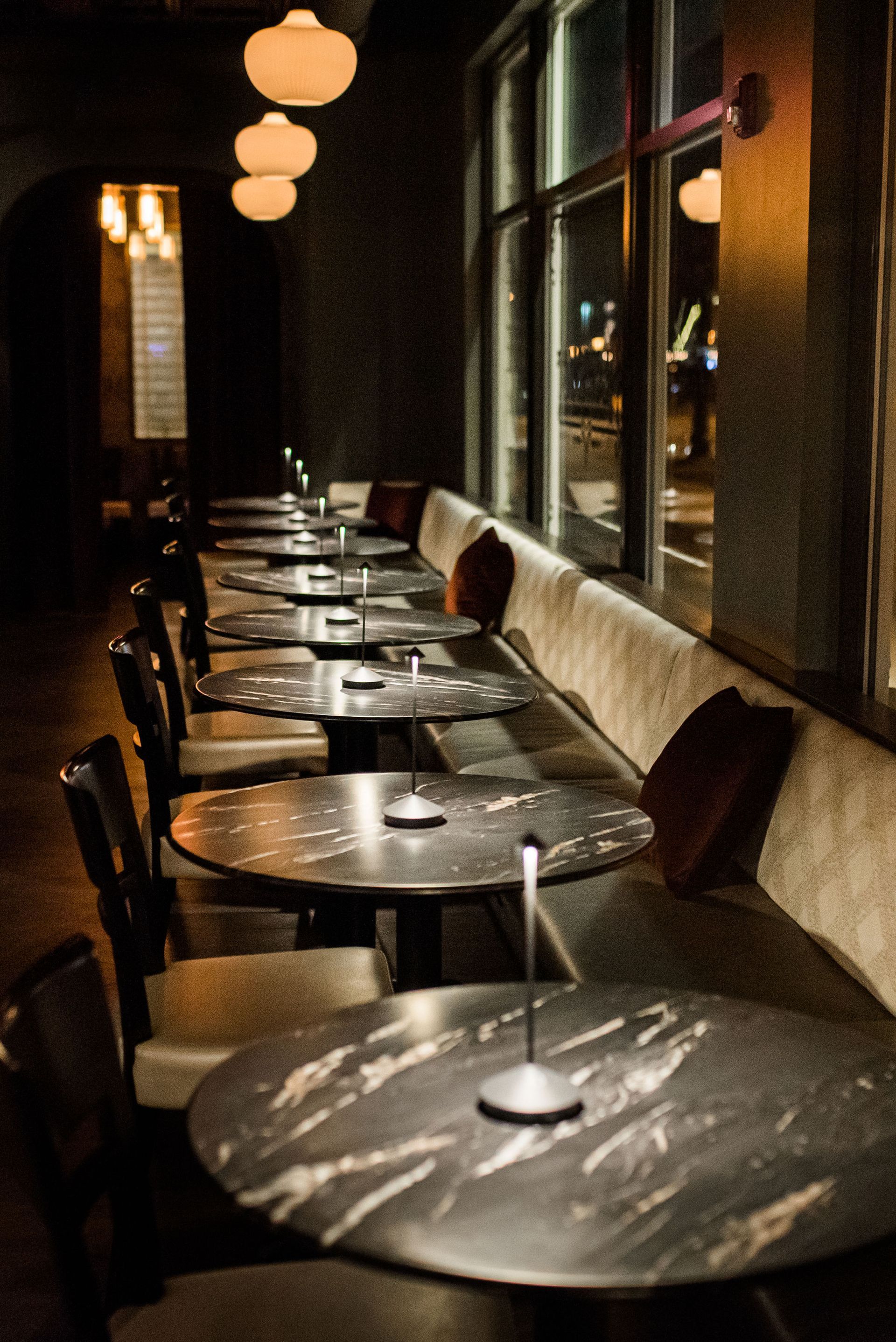 A row of tables in a restaurant with candles on them