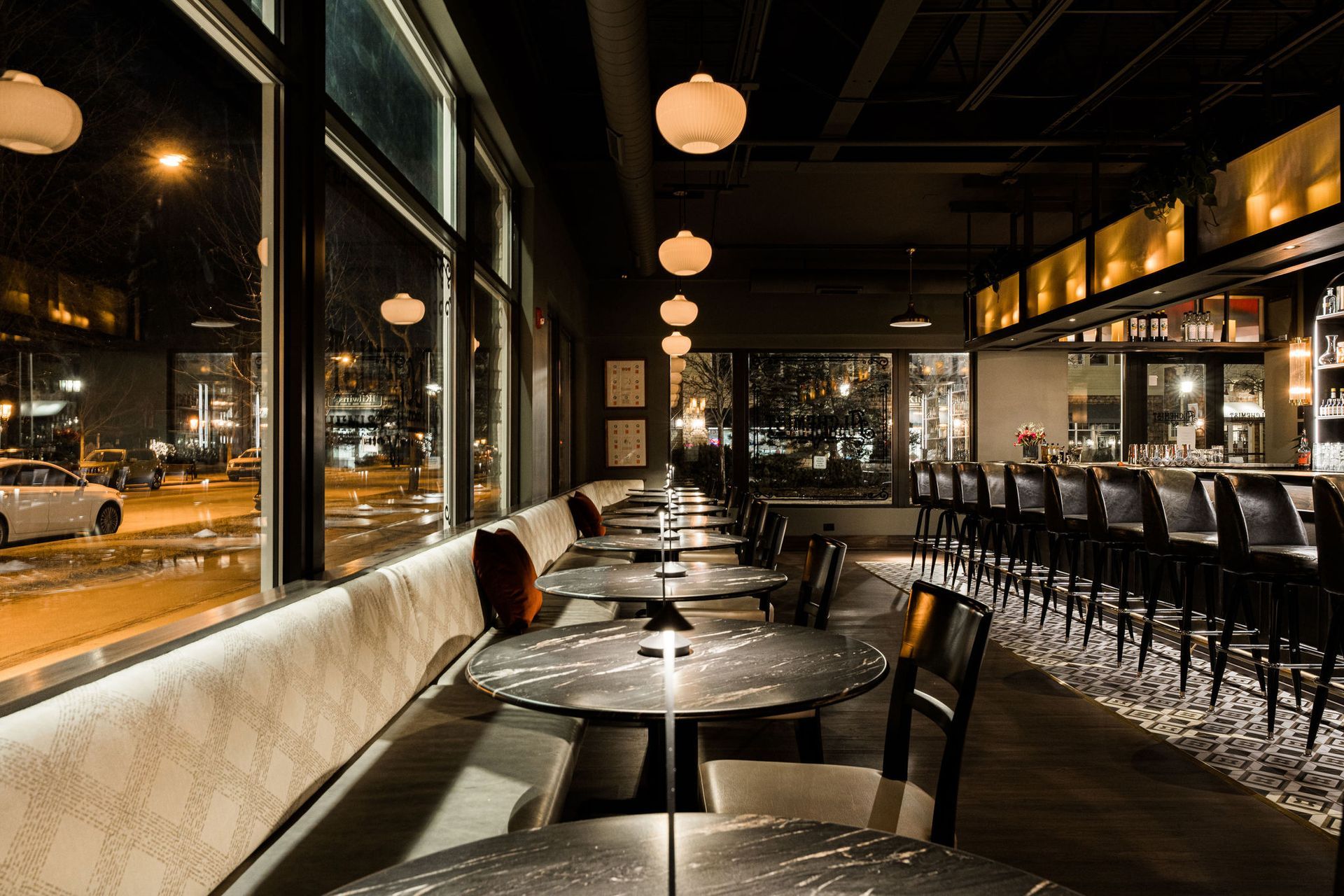 A restaurant with tables and chairs and a bar.