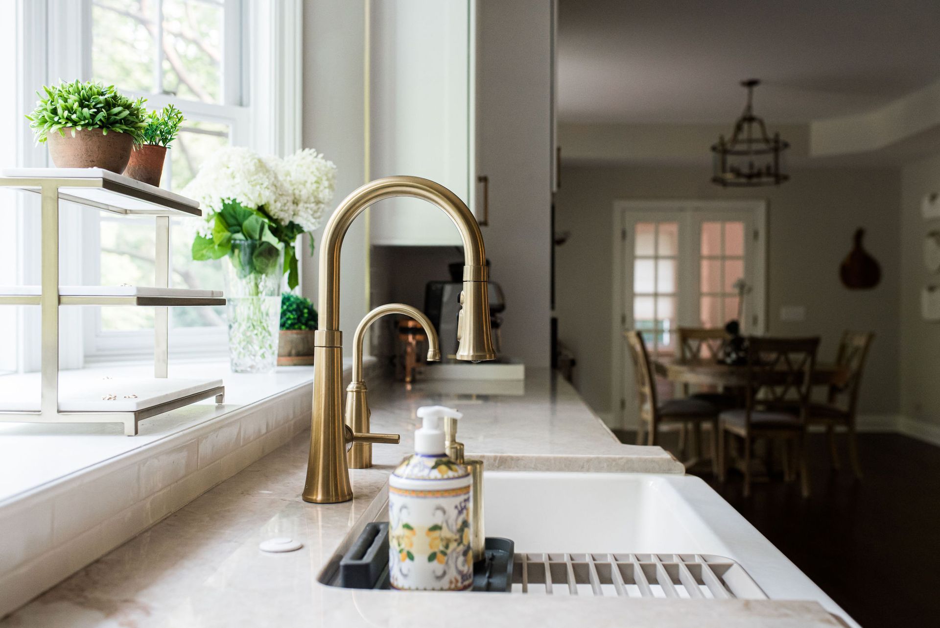A kitchen sink with a soap dispenser on the counter.