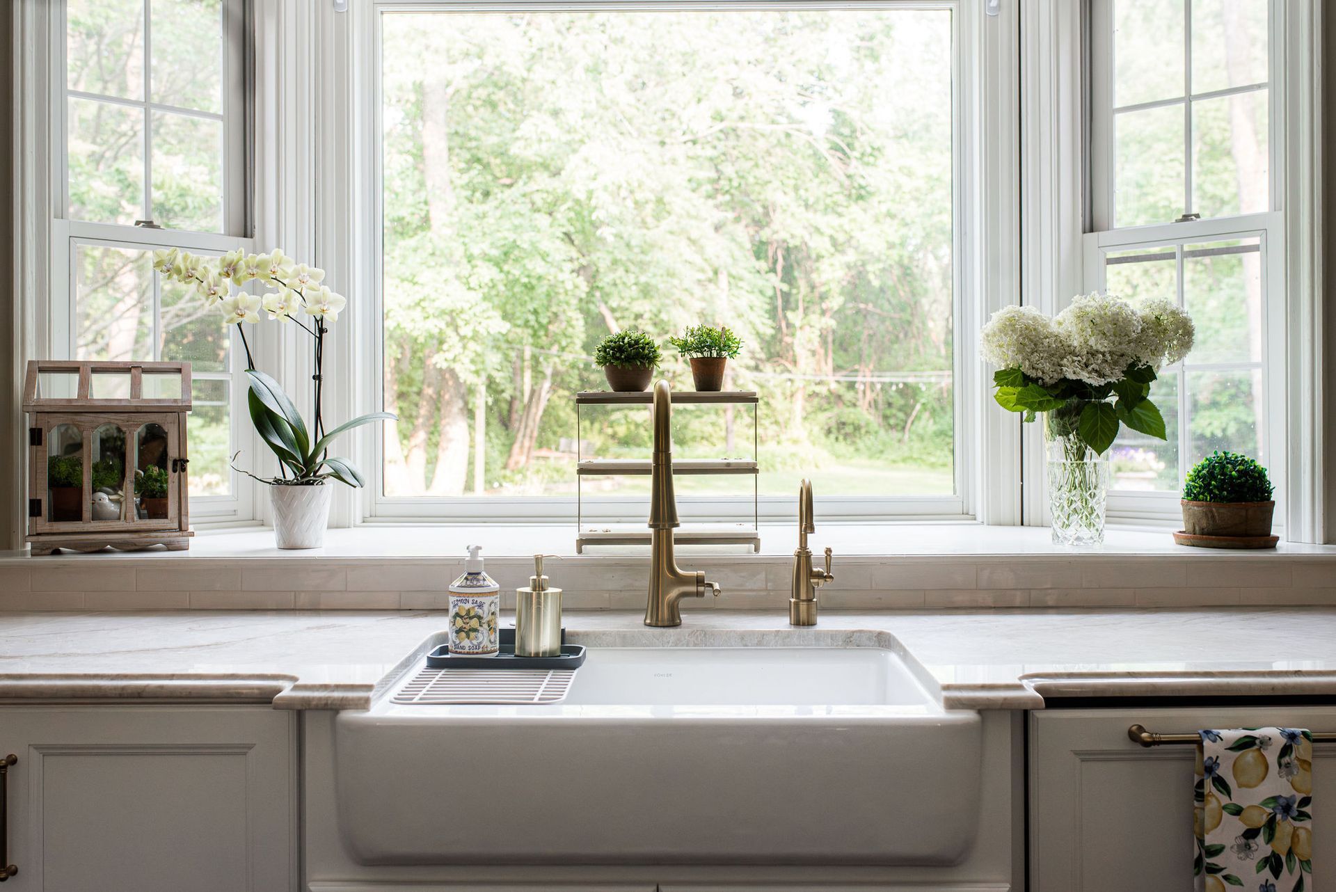 A kitchen sink is sitting under a window in front of a window.
