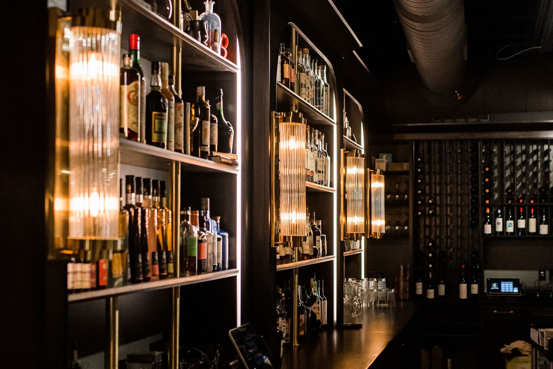 A bar with a lot of bottles of alcohol on shelves
