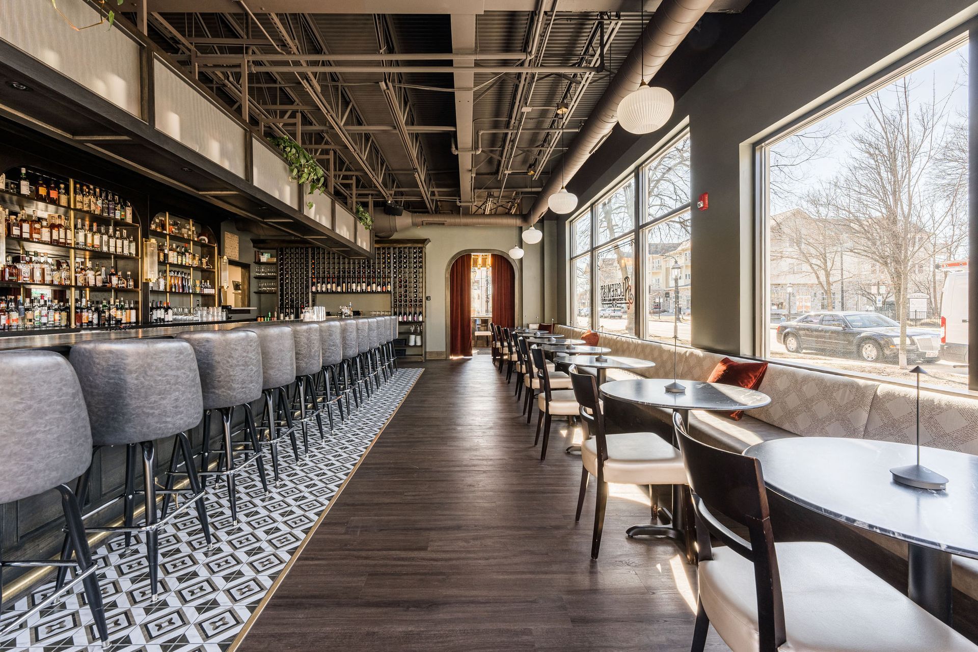 A long dining room with tables and chairs and a bar.