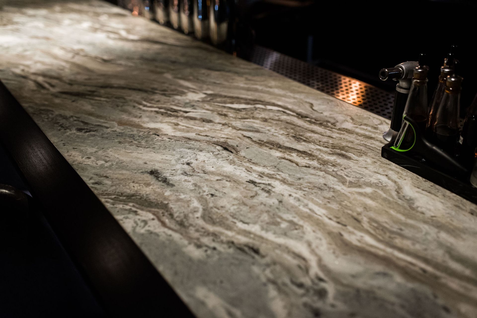 A close up of a marble counter top in a bar.