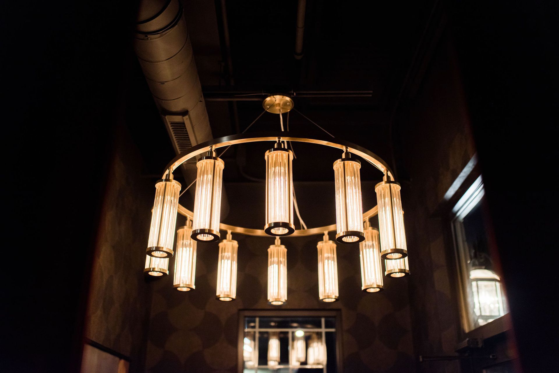 A large chandelier is hanging from the ceiling in a dark room.