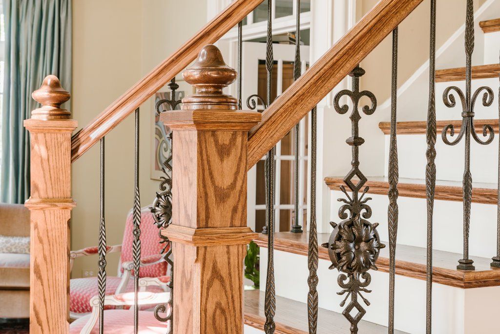 A wooden staircase with a wrought iron railing in a living room.