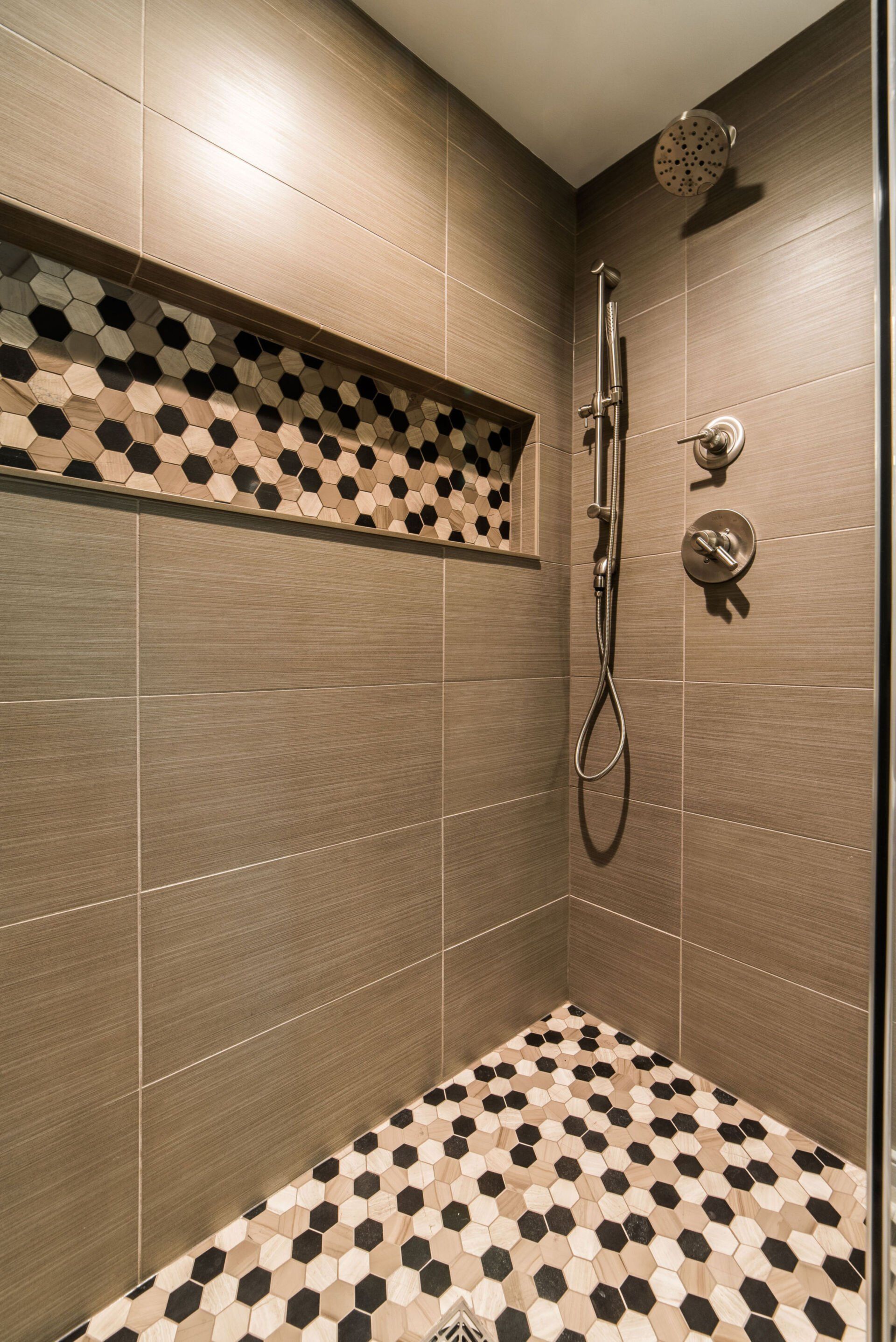 A shower with a tiled floor and a shower head.