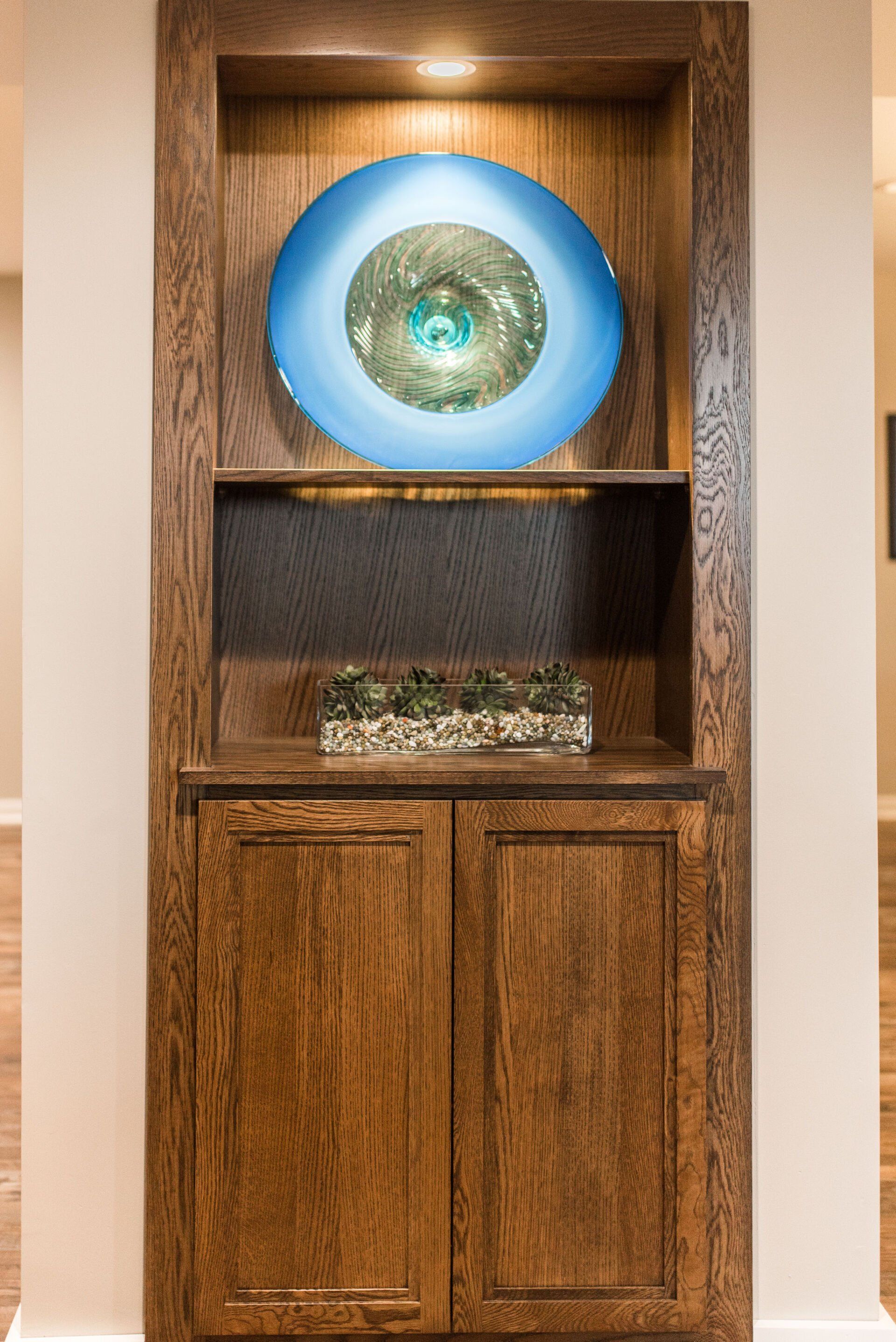 A blue plate is sitting on top of a wooden shelf.