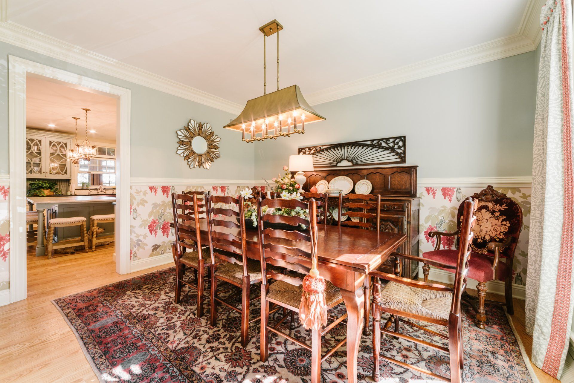 A dining room with a wooden table and chairs and a rug.