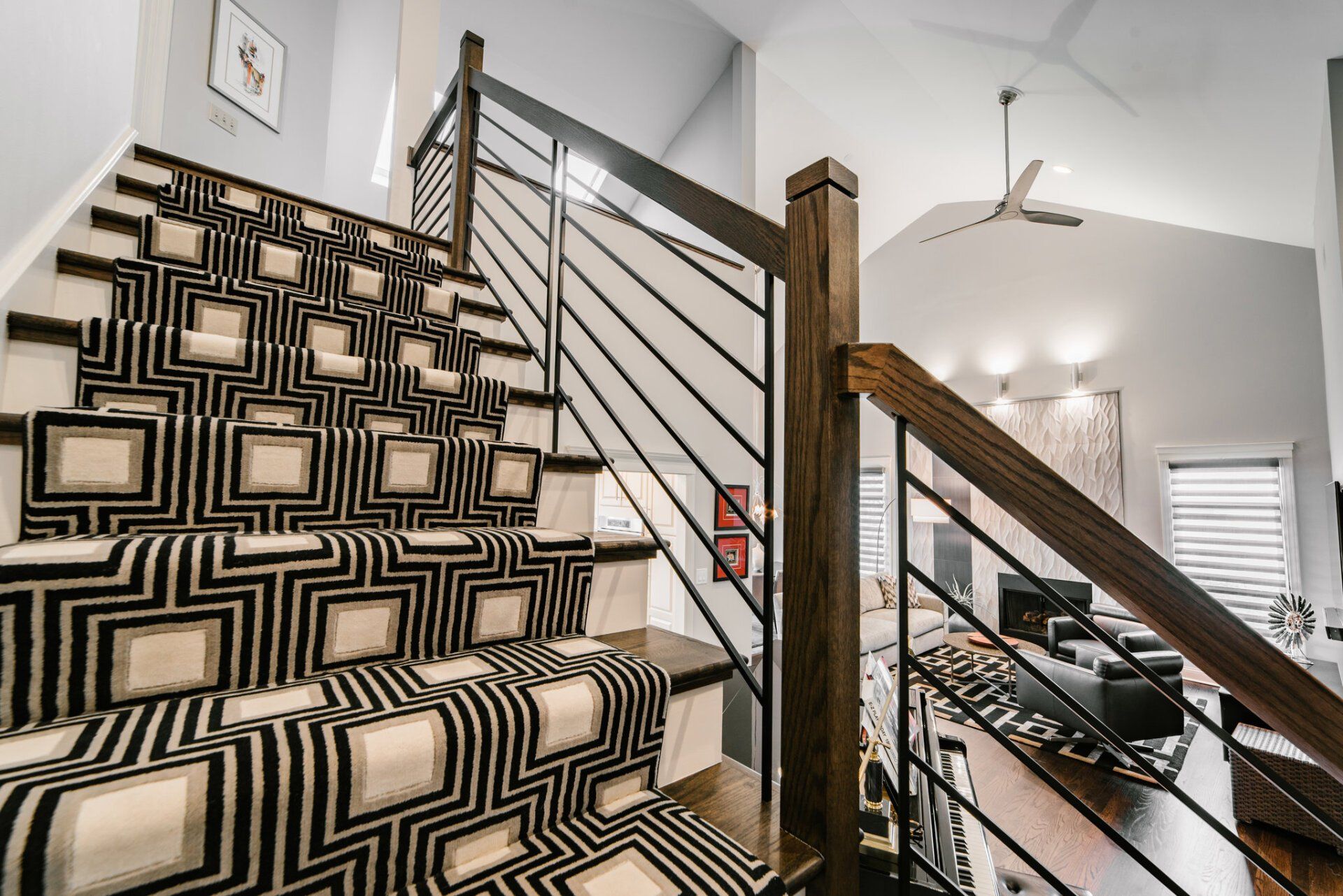 A black and white staircase with a black railing and a black and white carpet.