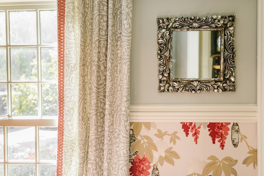 A mirror hanging on a wall next to a window