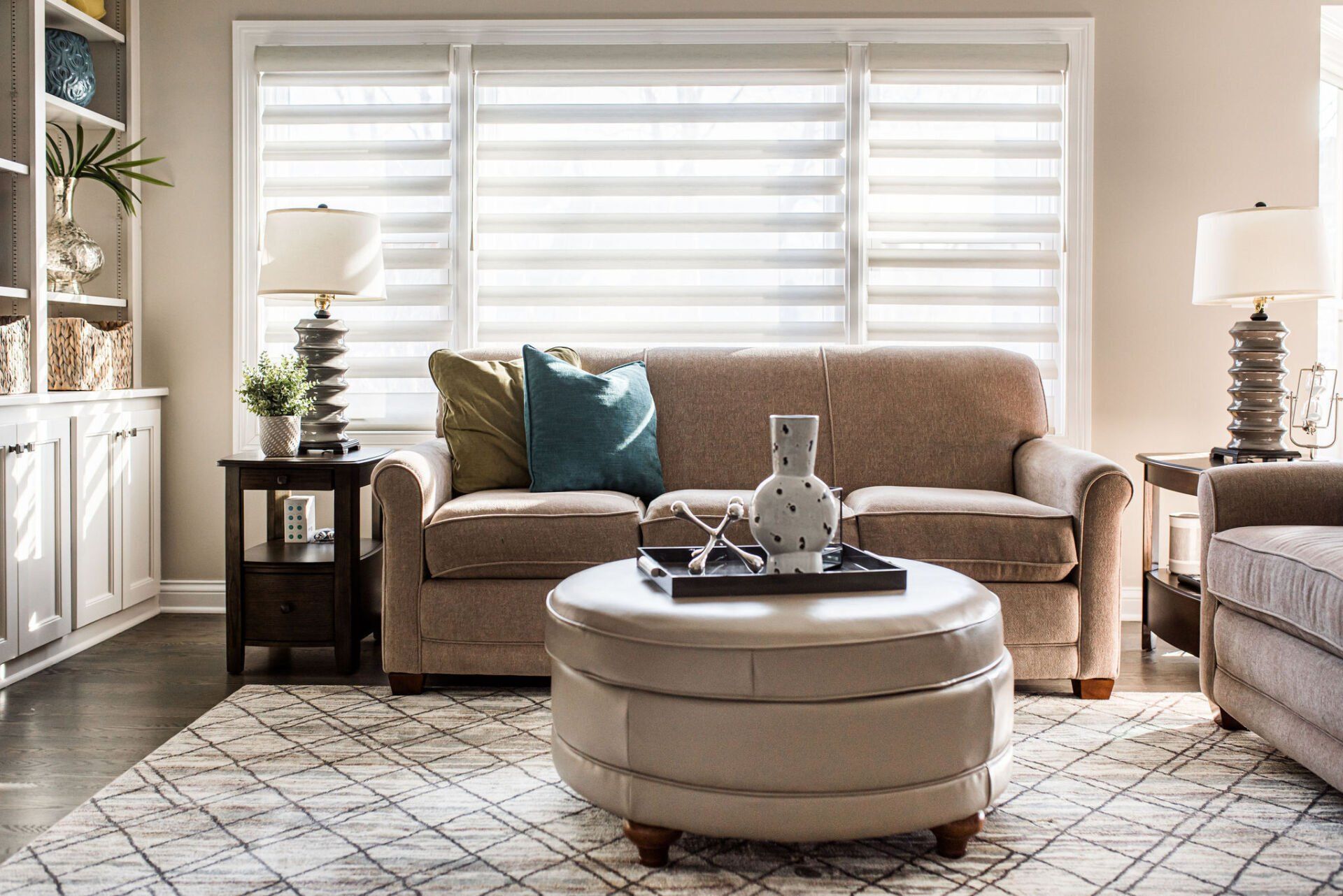 A living room with a couch , ottoman , and coffee table.