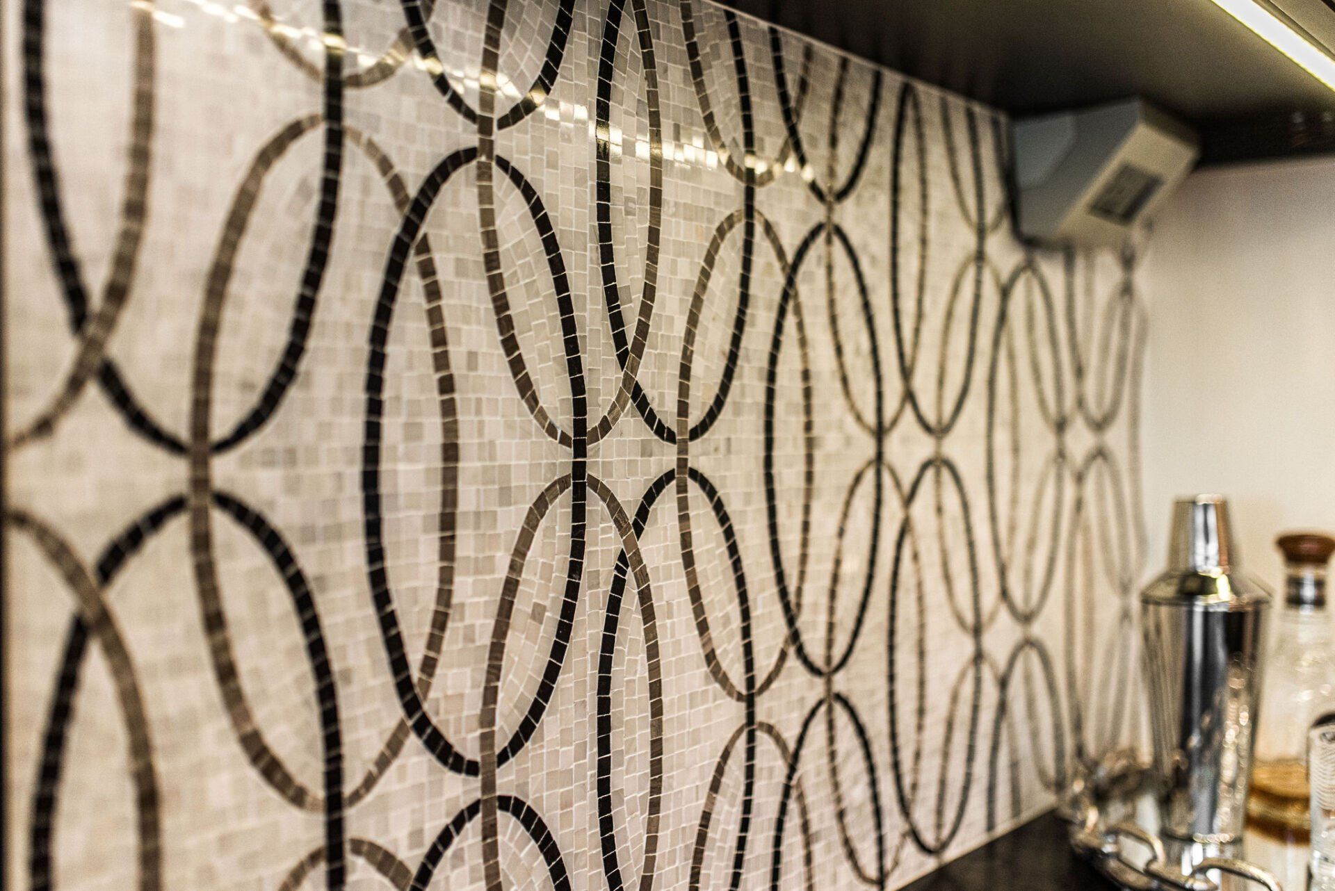 A close up of a mosaic tile wall in a kitchen.