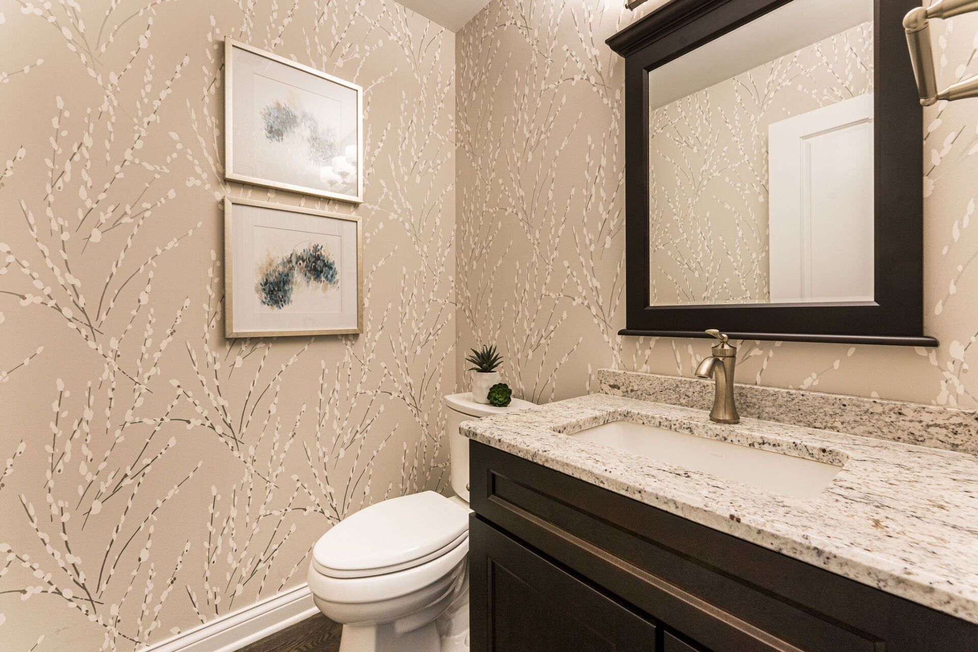 A bathroom with a toilet , sink and mirror.