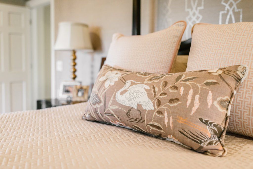 A bed with two pillows and a lamp on it.