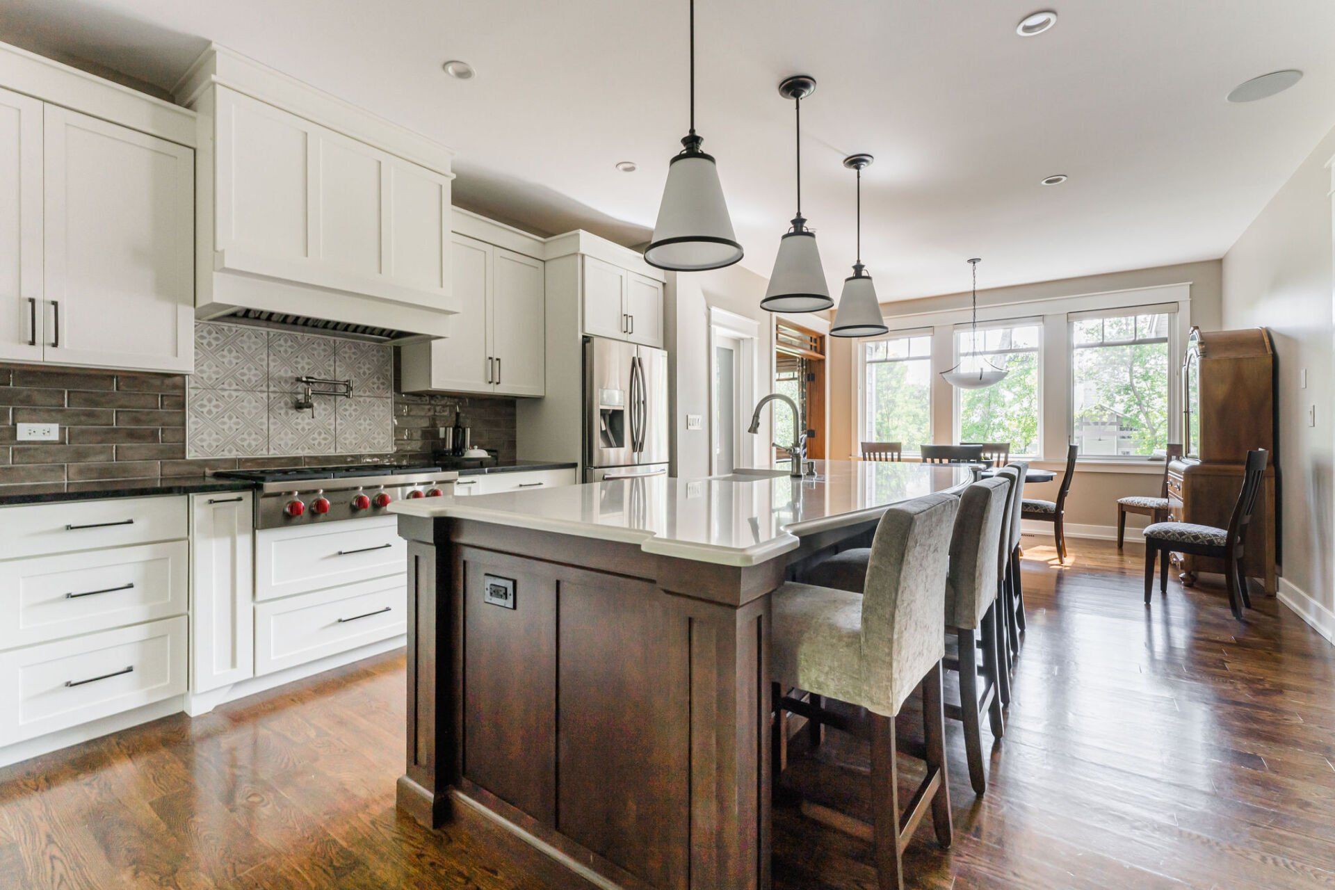 A kitchen with white cabinets and a large island in the middle.