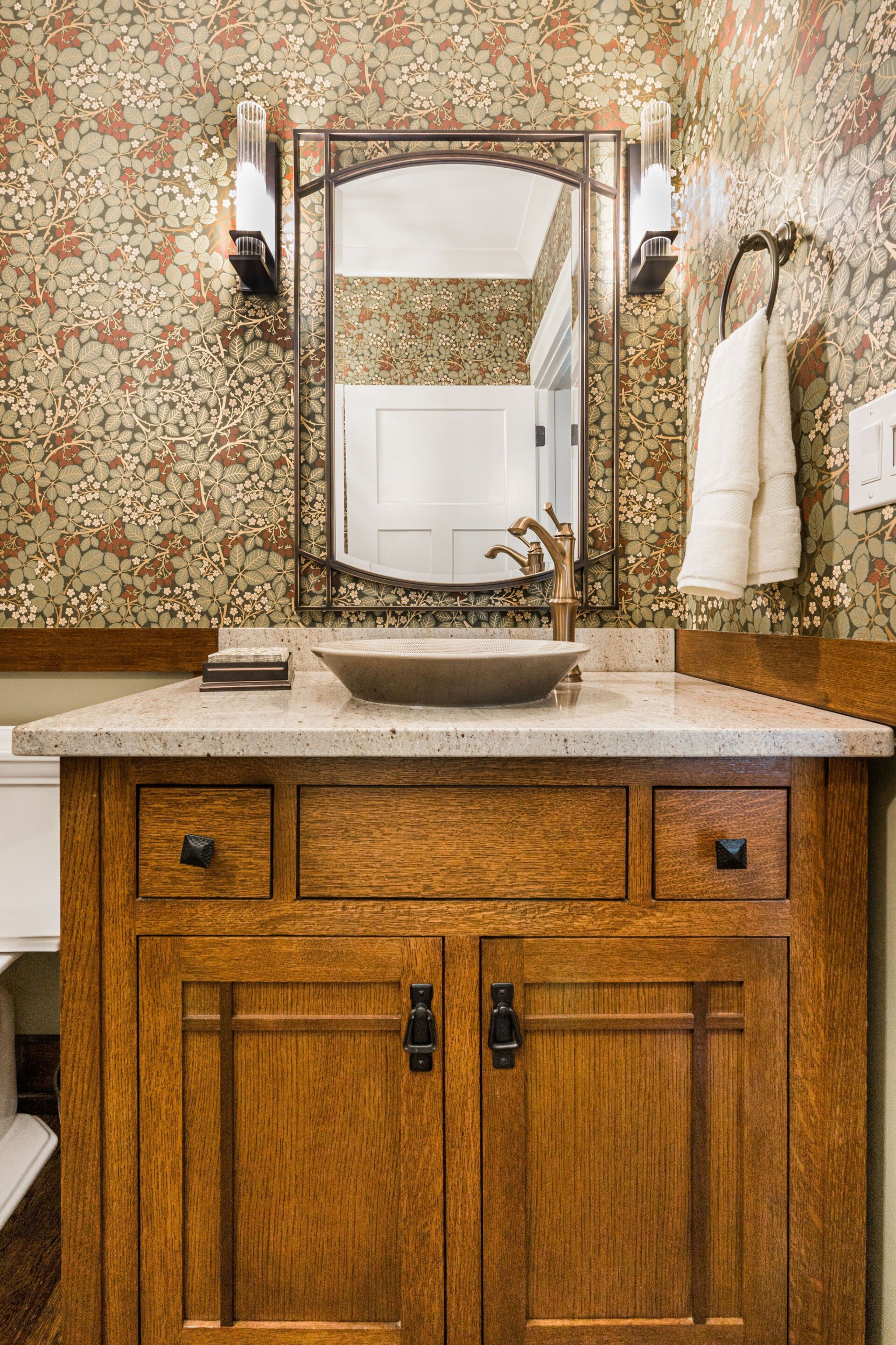 A bathroom with a wooden vanity , sink and mirror.