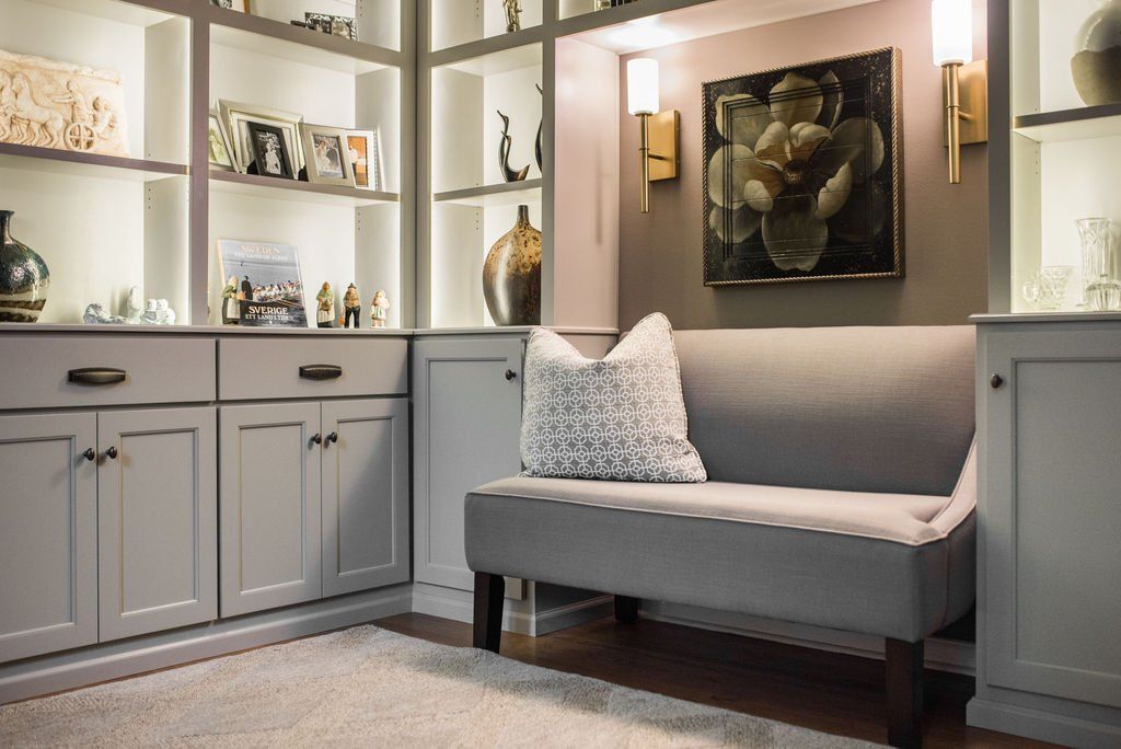 A living room with a couch and a painting on the wall.