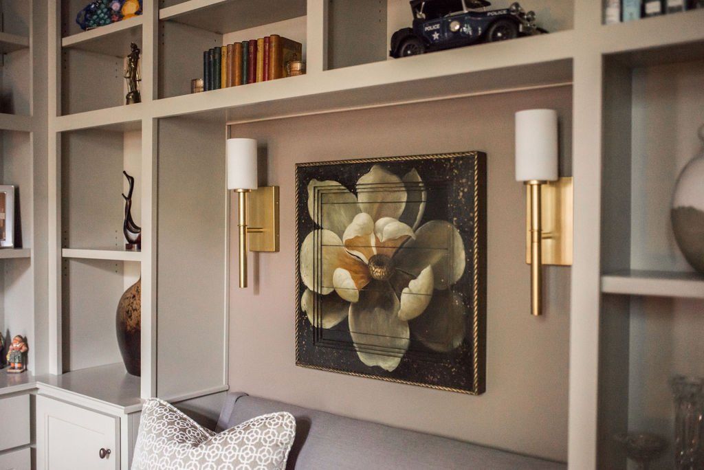 A living room with a couch and a painting on the wall.