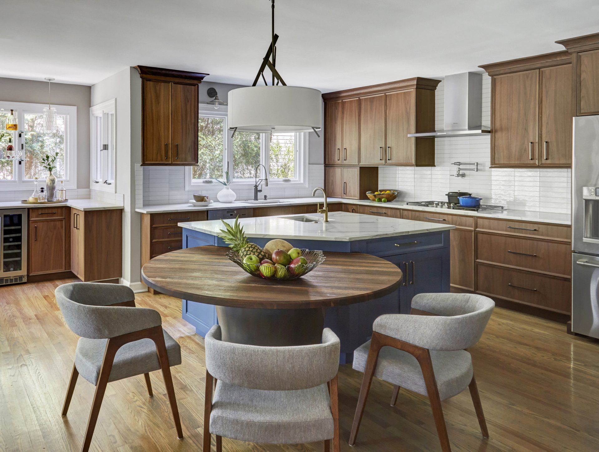 A kitchen with a table and chairs and a bowl of fruit on the table.