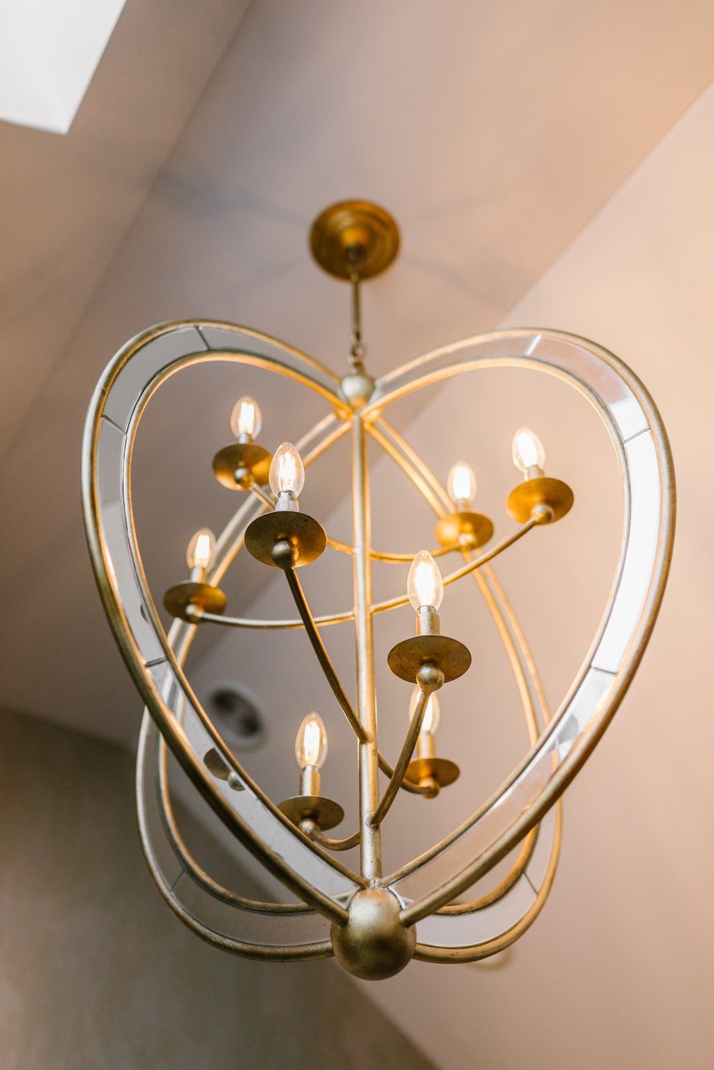 A heart shaped chandelier with candles hanging from the ceiling.