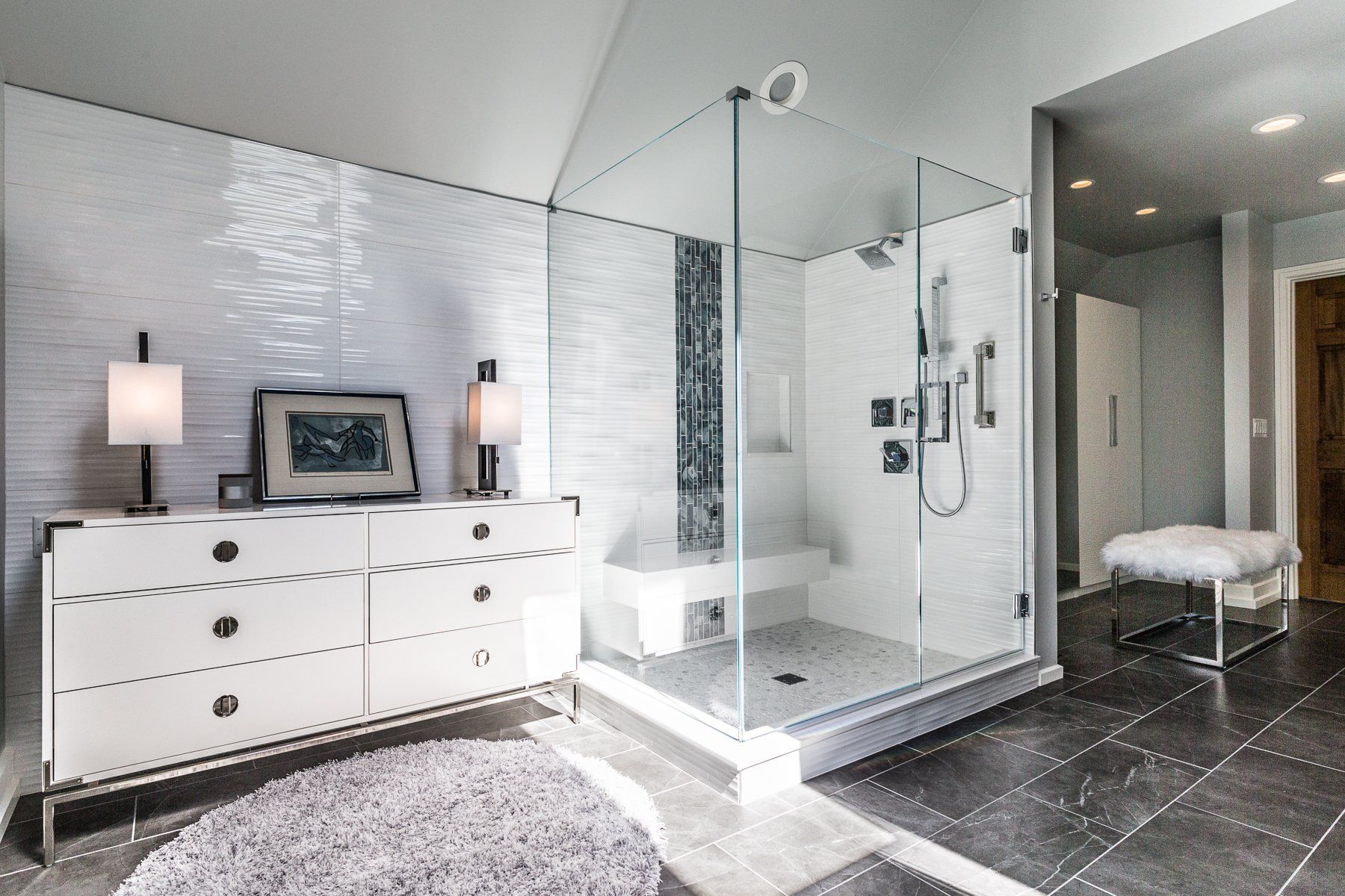 A bathroom with a walk in shower and a dresser.