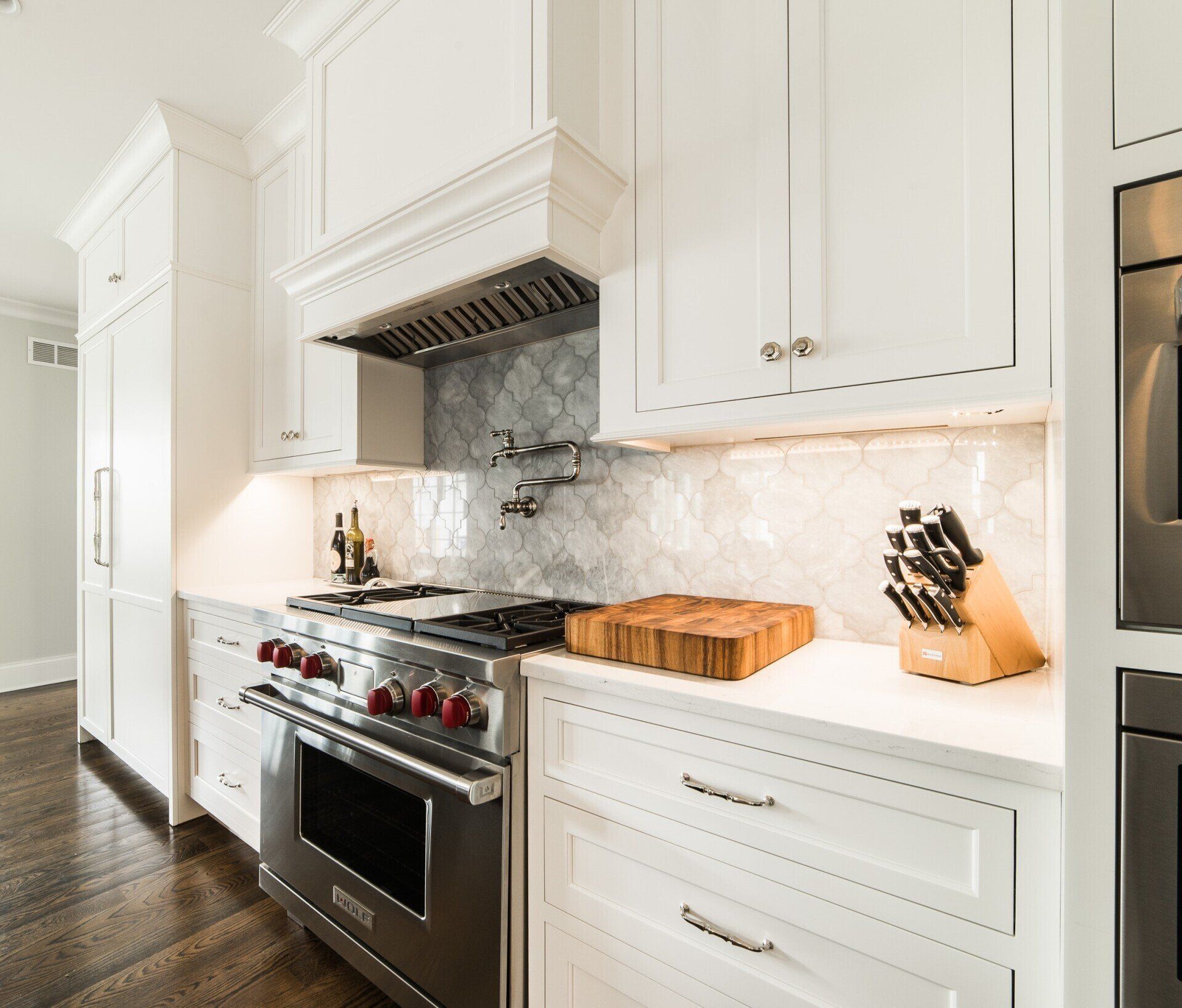 A kitchen with white cabinets and stainless steel appliances