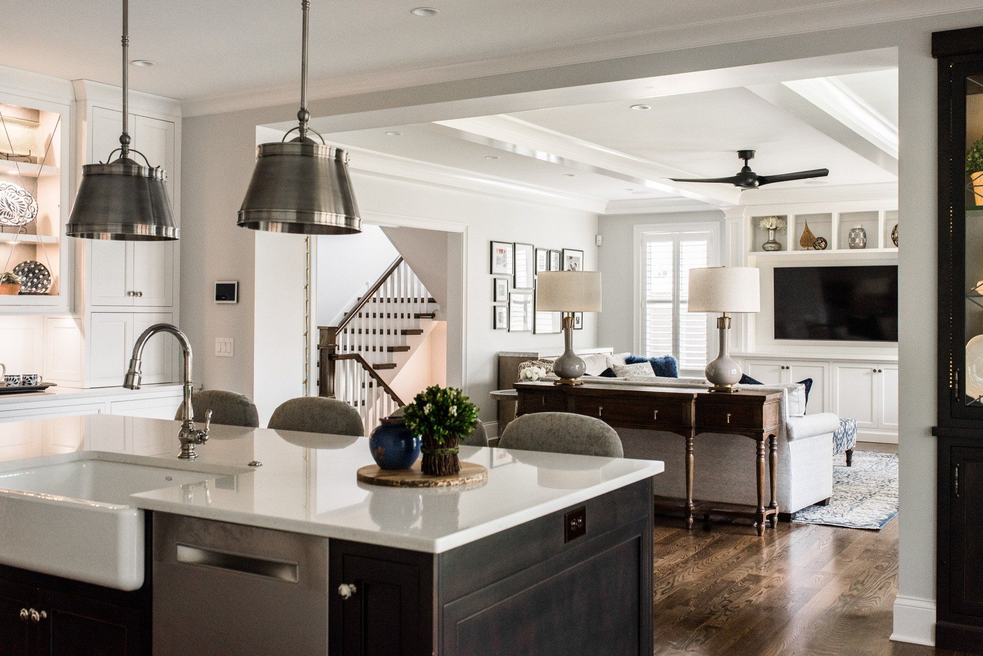 A kitchen with a large island in the middle of it and a living room in the background.