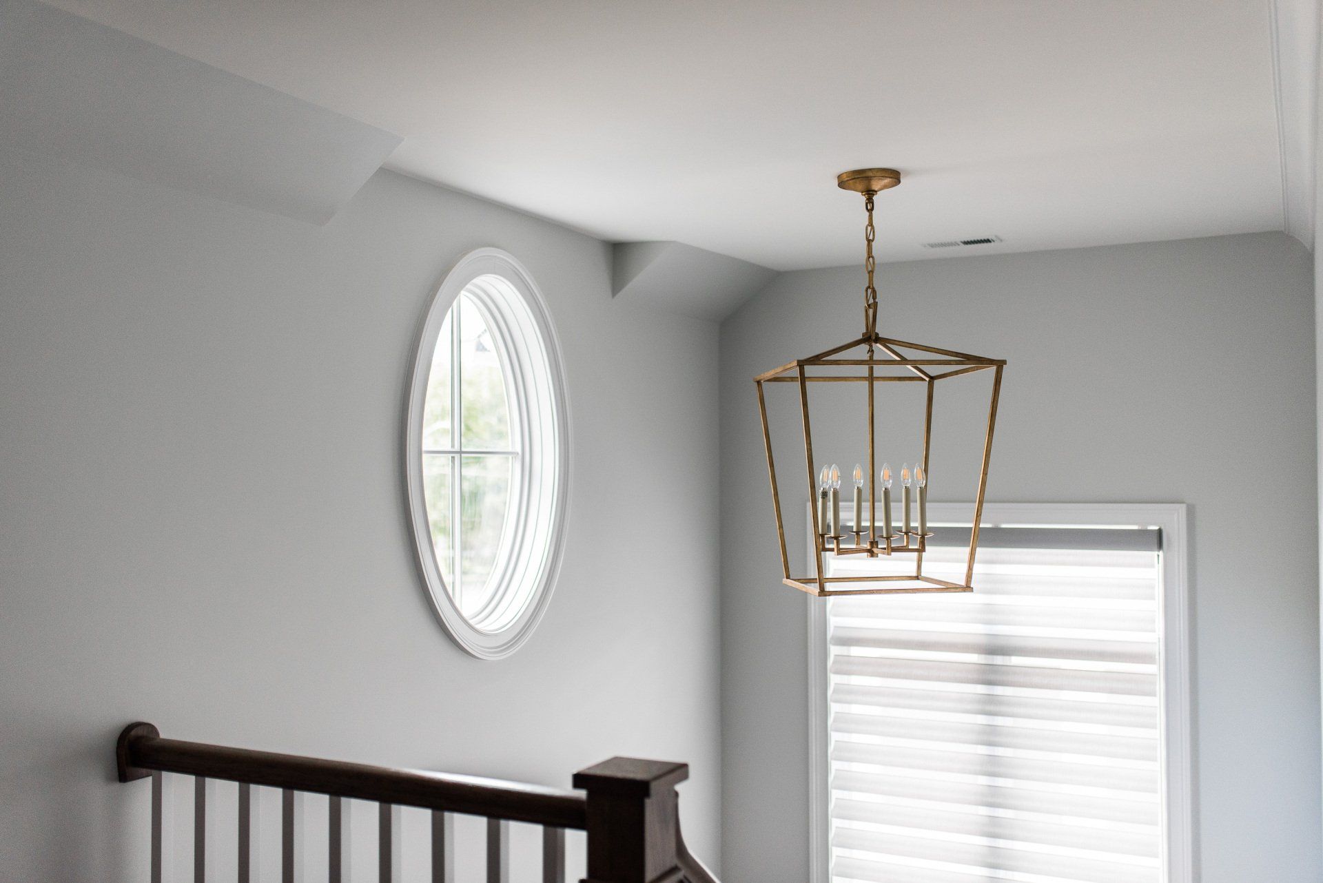 A staircase with a lantern hanging from the ceiling and a window.