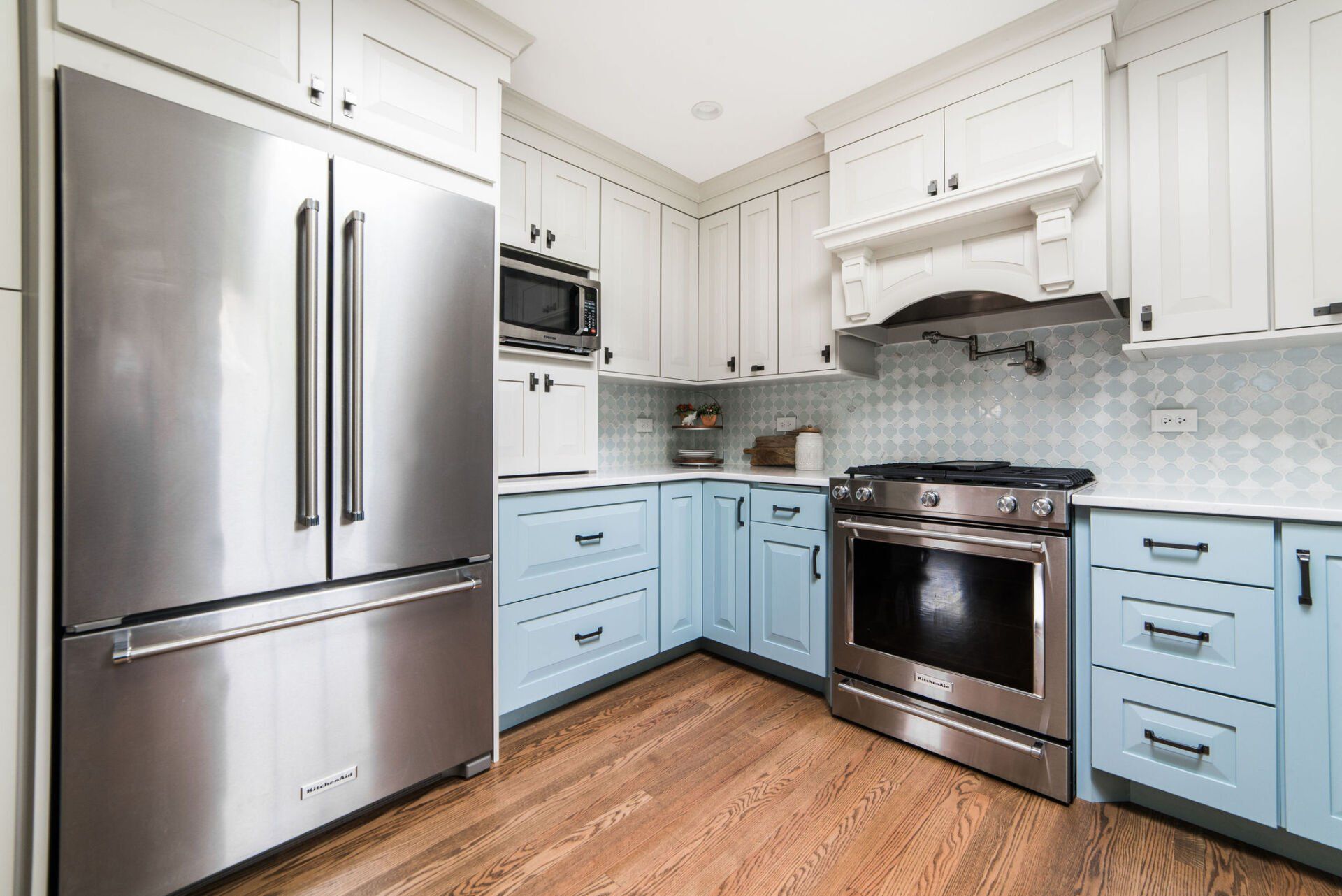 A kitchen with blue cabinets and stainless steel appliances.