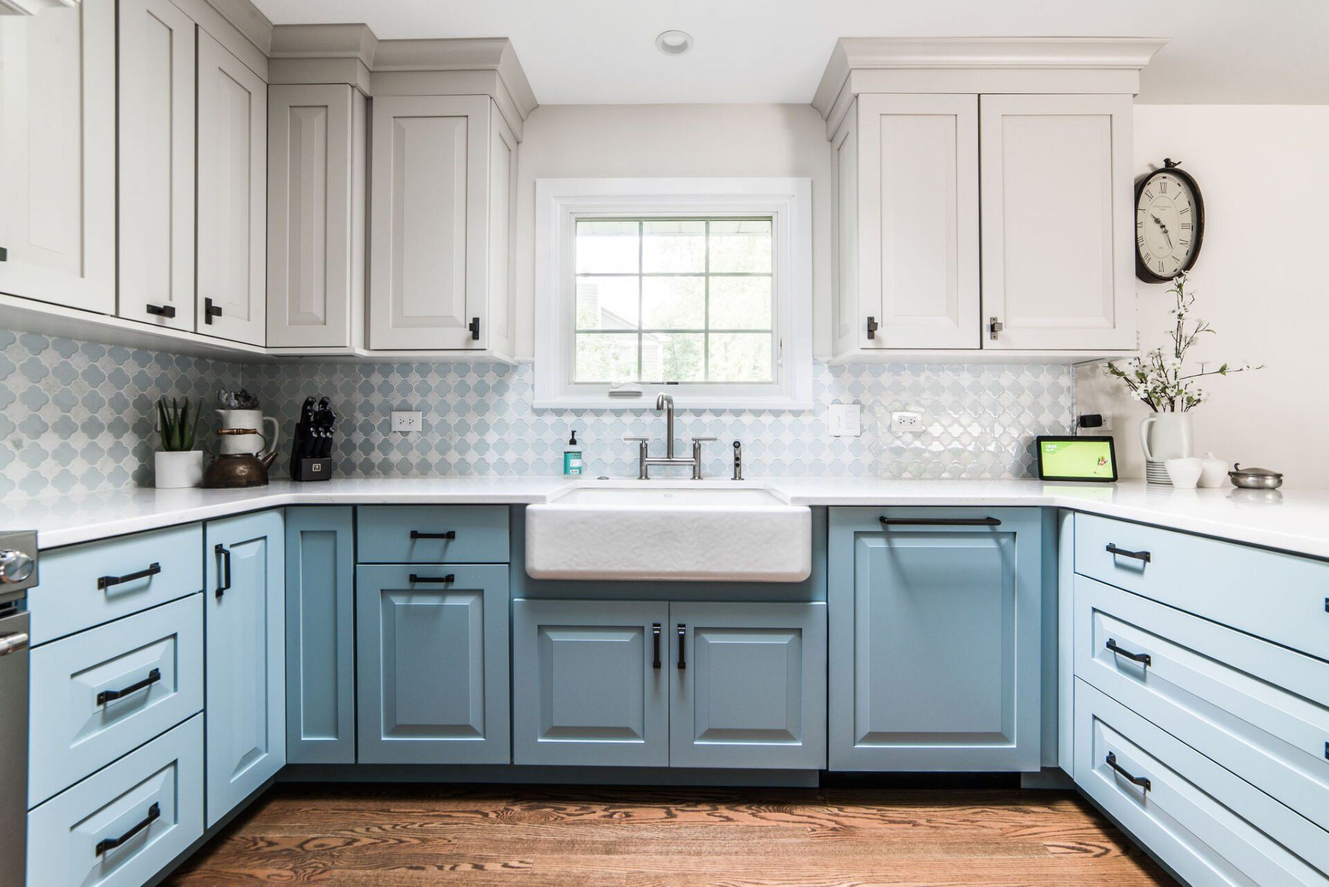 A kitchen with blue cabinets and white counter tops and a sink.
